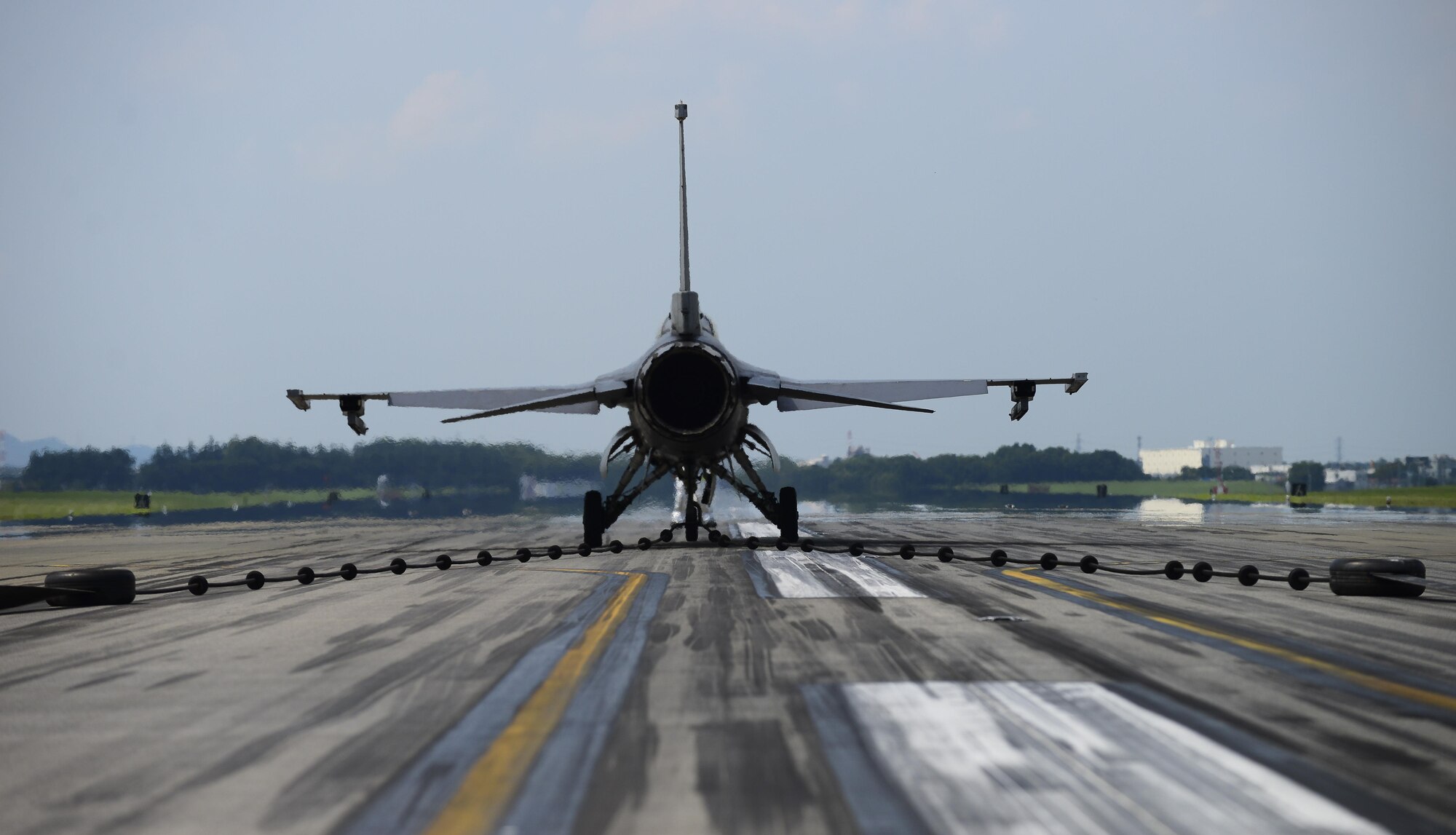 A U.S. Air Force F-16 Fighting Falcon from Misawa Air Base, Japan, slows down on the runway at Yokota Air Base, Japan, June 24, 2015. As the reel of the aircraft arresting system spins it activates a hydraulic pump which compresses a brake pad to safely slow the aircraft. The aircraft can go from a speed of 180 knots to a complete hault in approximately 10 seconds. (U.S. Air Force photo by Senior Airman David Owsianka/Released)