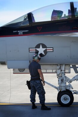 Aviation Electrician's Mate 3rd Class Lucas McLean, assigned to Strike Fighter Squadron (VFA) 154, Lemoore, California, Looks over a F/A-18F Super Hornet during Exercise Northern Edge 15 at Joint Base Elmendorf-Richardson, Alaska, June 18, 2015. Northern Edge 2015 is Alaska’s premier joint training exercise designed to practice operations, techniques and procedures as well as enhance interoperability among the services. Thousands of participants from all services, from active duty, Reserve and National Guard units, are involved. (U.S. Air Force photo by Staff Sgt. William Banton/Released)‪