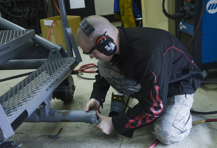 U.S. Air Force Airman 1st Class Curtis Doherty, 374th Maintenance Squadron aircraft metals technology journeyman, places a tow bar into a B-1 platform to ensure it correctly fits at Yokota Air Base, Japan, June 23, 2015. The platform is used for high and overhead maintenance or production jobs that are six to 18 feet above the floor. (U.S. Air Force photo by Senior Airman David Owsianka/Released)
