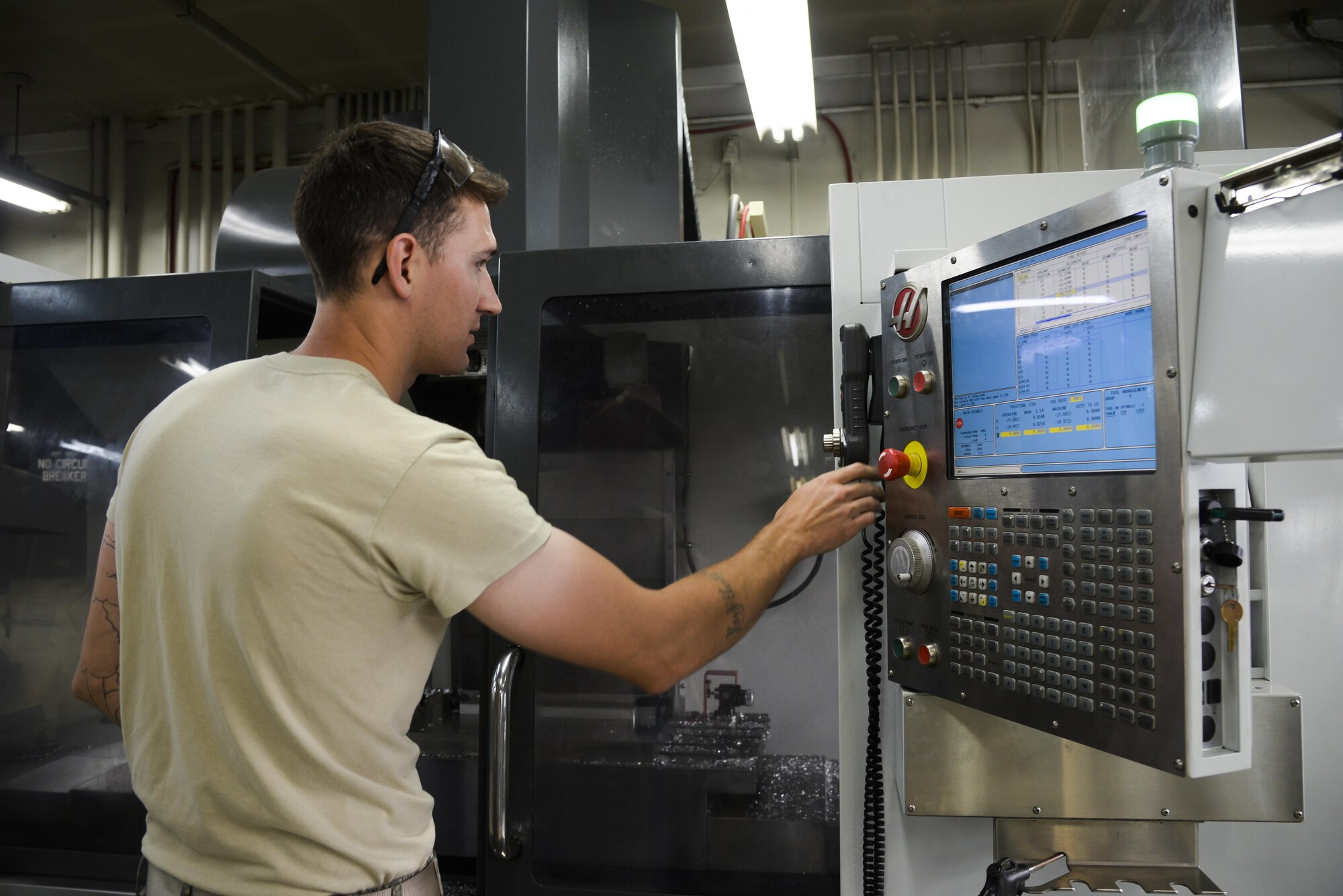 U.S. Air Force Senior Airman Justin Weeks, 374th Maintenance Squadron aircraft metals technology journeyman, inputs information into the computer numeric controller router to create a C-130 Hercules part in the fabrication shop at Yokota Air Base, Japan, June 23, 2015. Numerical conrols the automation of machine tools that are operated by precisely programmed commands encoded on a storage medium. (U.S. Air Force photo by Senior Airman David Owsianka/Released)