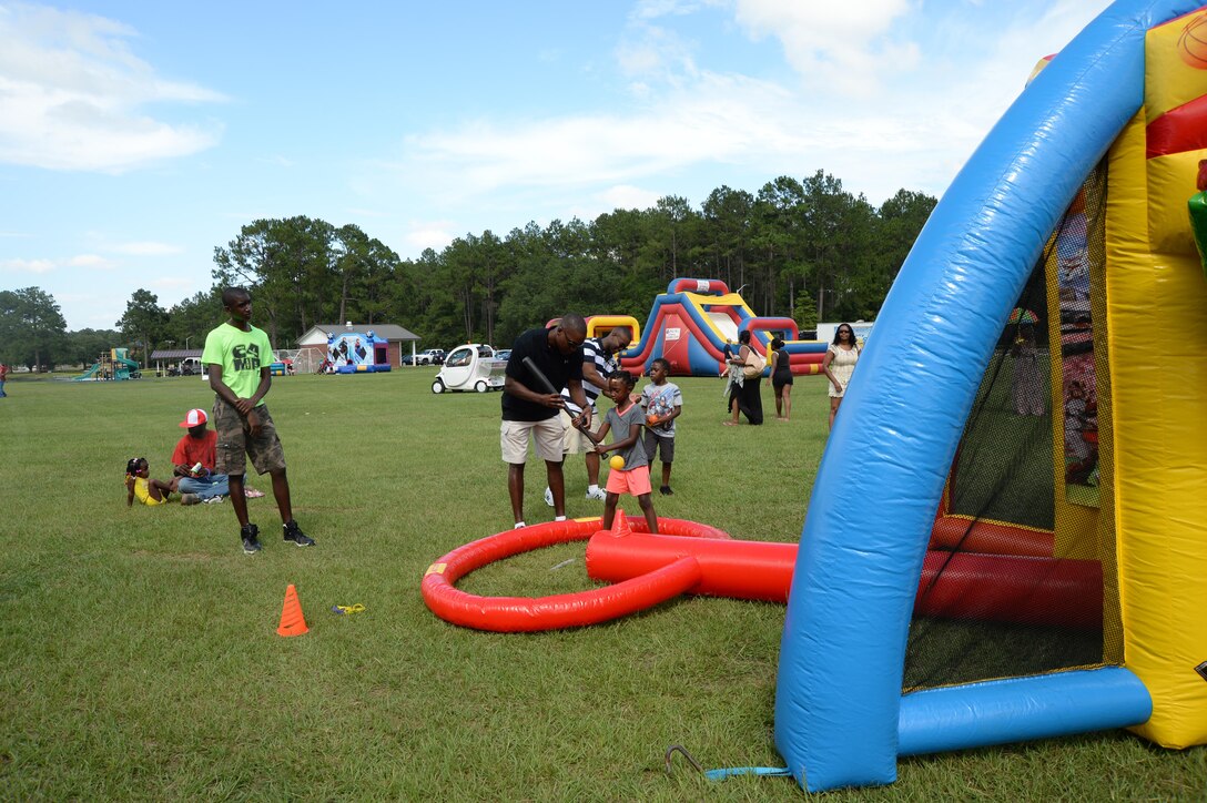 A child gets swinging tips from Lt. Col. Nathaniel Robinson, executive officer, Marine Corps Logistics Base Albany, during the Independence Day celebration, June 26, held at Marine Corps Logistics Base Albany.
