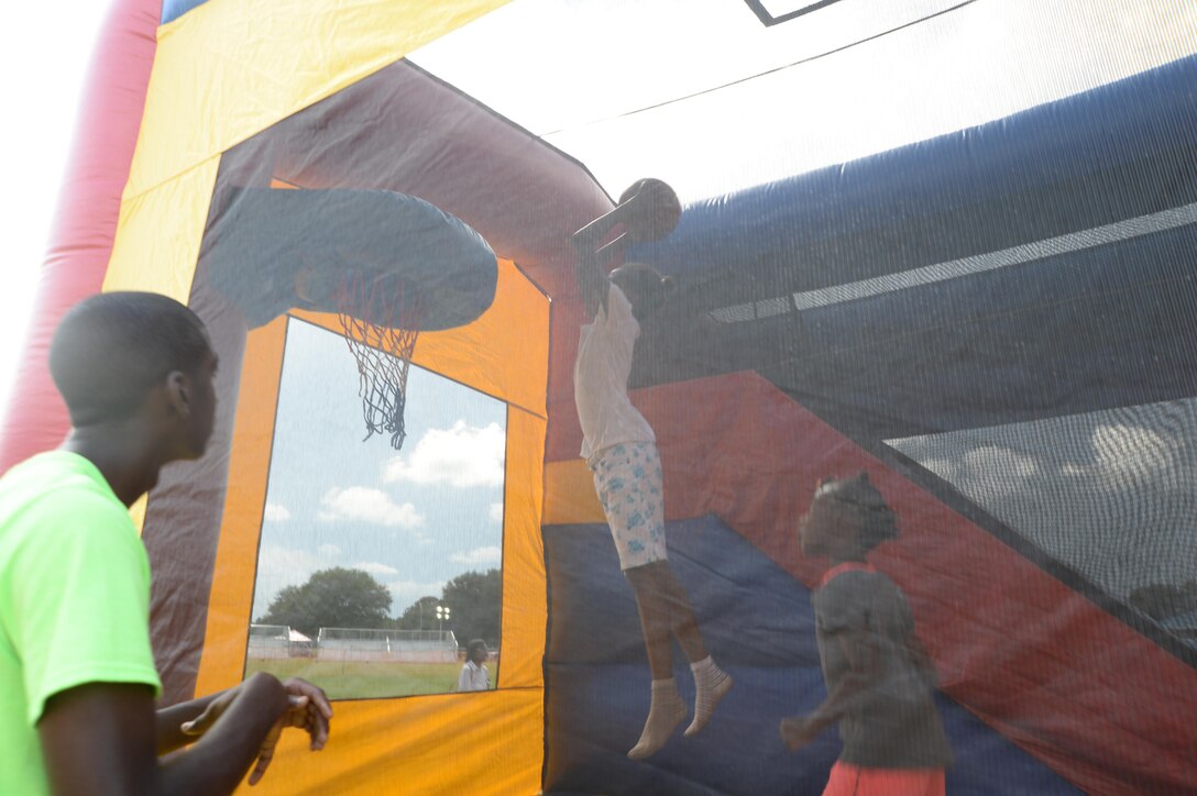 A child leaps high in the air to dunk a basketball during the Independence Day celebration, June 26, held at Marine Corps Logistics Base Albany.