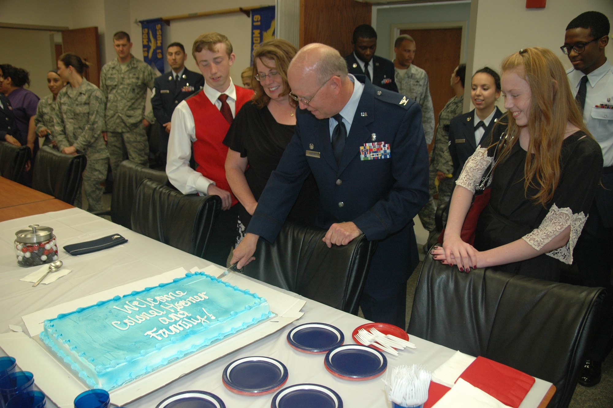 Col. (Dr.) Paul J. Hoerner, incoming 61st Medical Squadron commander cuts into a ceremonial cake welcoming him, his wife Karen, son Ryan and daughter Rachel. As the newest commander of the 61st MDS, Hoerner is responsible for ensuring more than 1,200 active duty personnel assigned to the Space and Missile Systems Center at Los Angeles Air Force Base are medically fit and ready for contingency (natural disasters and wartime) operations. He commands a staff of 178 active duty, government civilians and contract medical staff providing care for more than 171,000 eligible patients across the greater Los Angeles metropolitan area. (U.S. Air Force photo/Jim Spellman) 