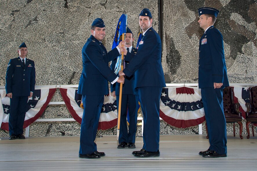 Col. Jonathan Duncan, 336th Training Group commander, takes the 36th Rescue Flight guidon from Maj. Jennings Marshall, former 36th Rescue Flight commander, during the 36th RQF change of command ceremony June 25, 2015, at Fairchild Air Force Base, Wash. The change of command ceremony is an official, formal and brief ceremony that is the military’s way of bestowing command responsibility of a unit from one officer to another. (U.S. Air Force photo/Staff Sgt. Benjamin W. Stratton)