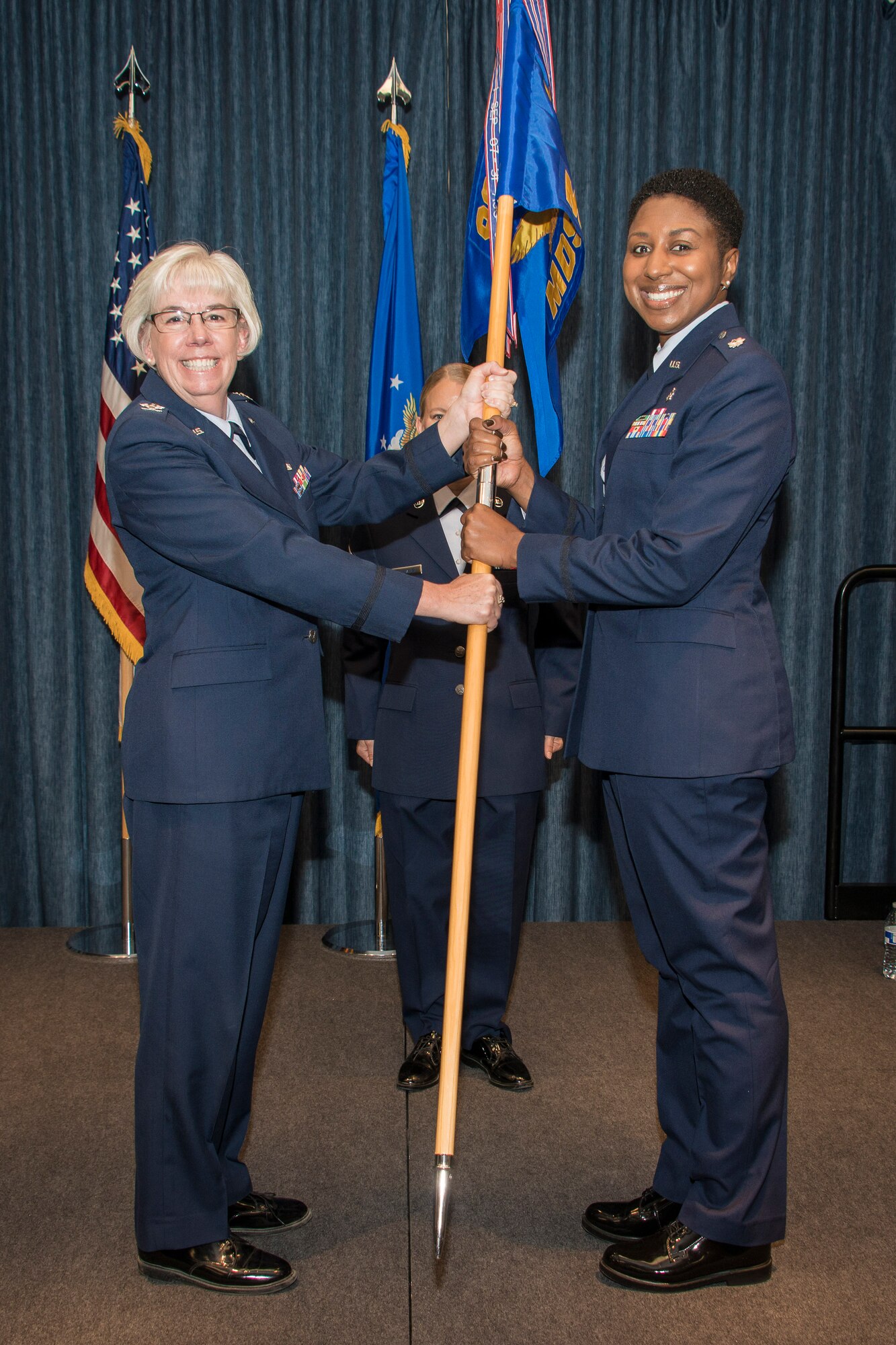 Col. Margaret Carey, 92nd Medical Group commander, hands the 92nd Medical Support Squadron guidon to Lt. Col. Felicia Burks, 92nd MDSS commander, during the 92nd MDSS change of command ceremony June 26, 2015, at Fairchild Air Force Base, Wash. The change of command ceremony is an official, formal and brief ceremony that is the military’s way of bestowing command responsibility of a unit from one officer to another. This ceremony formalizes the change of command by the passing of the symbol of command, the squadron guidon, from the relinquishing commander to the gaining commander. (U.S. Air Force photo/Staff Sgt. Benjamin W. Stratton)