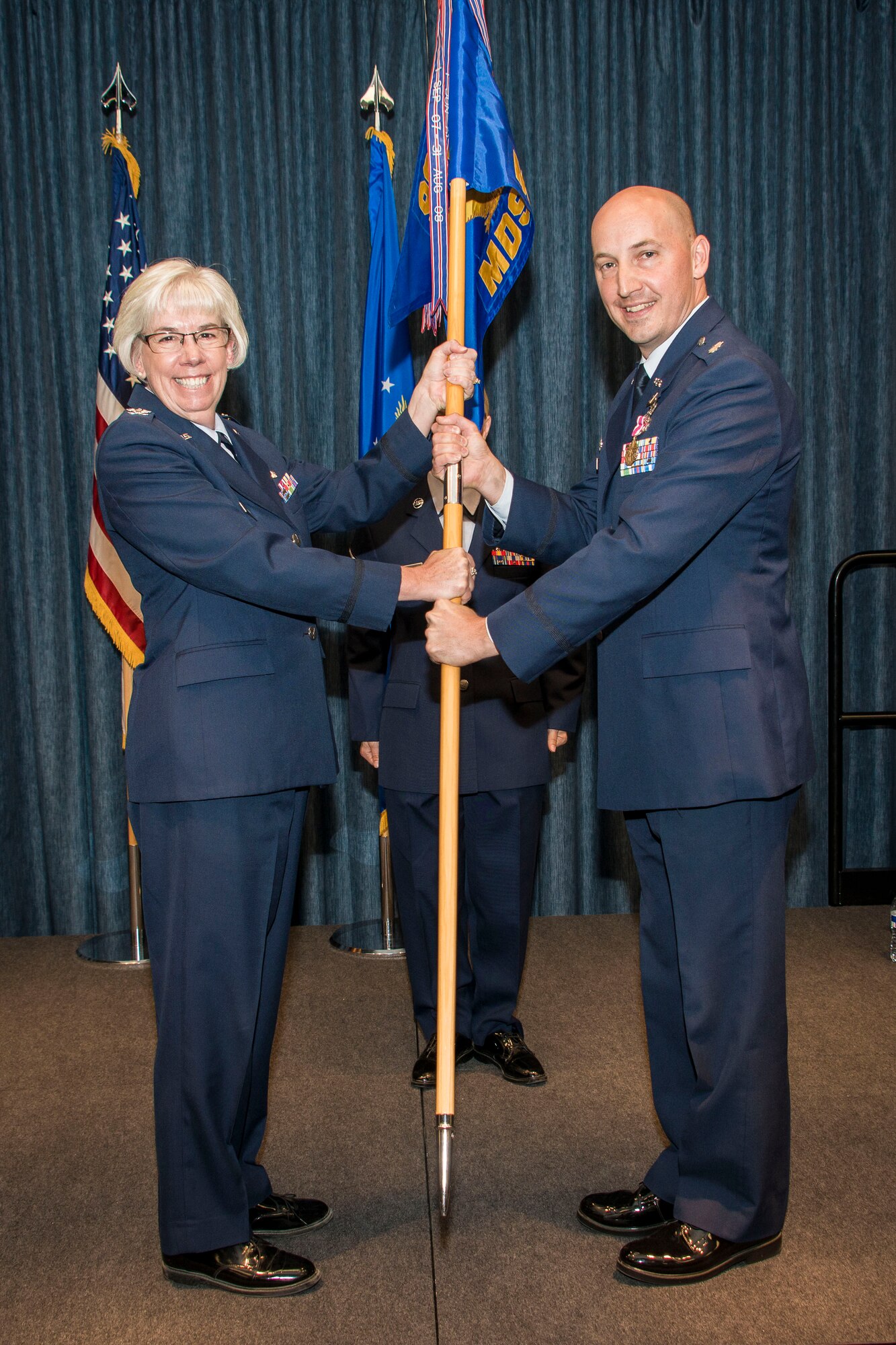 Col. Margaret Carey, 92nd Medical Group commander, takes the 92nd Medical Support Squadron guidon from Lt. Col. Richard Broyer, former 92nd MDSS commander, during the 92nd MDSS change of command ceremony June 26, 2015, at Fairchild Air Force Base, Wash. Broyer is a certified professional in healthcare information and management systems and a certified defense financial manager. He earned his commission in 1996 entering with a master’s degree in Healthcare Administration. (U.S. Air Force photo/Staff Sgt. Benjamin W. Stratton)