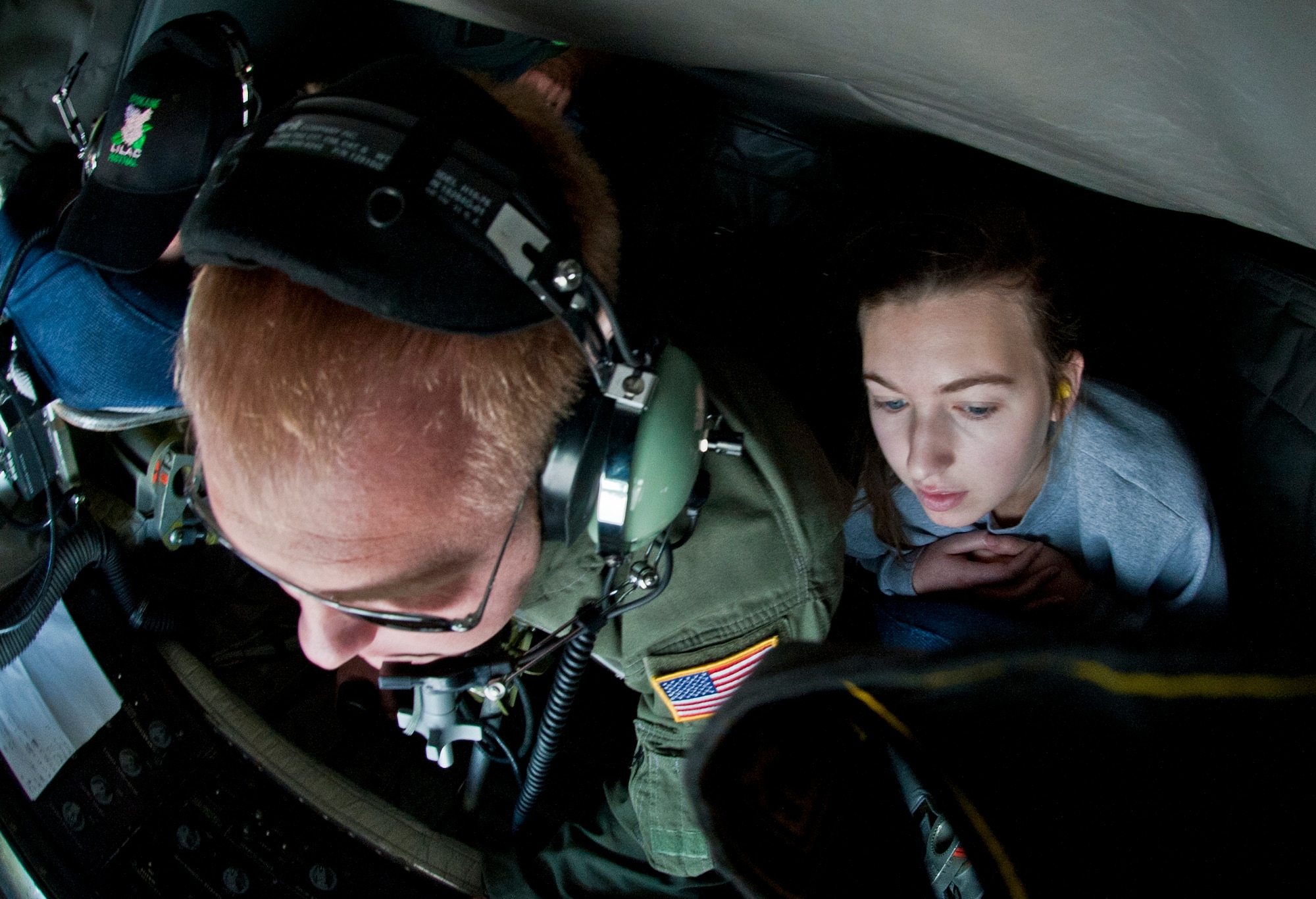 Chandler Stein, Lilac Princess, looks on as Staff Sgt. Jason Markham, 93rd Air Refueling Squadron boom operator, operates the boom pod aboard a KC-135 Stratotanker to refuel an F-15E Strike Eagle June 25, 2015, over the Inland Northwest. The Lilac Princesses Royal Court members were aboard the aircraft as part of an orientation flight. (U.S. Air Force photo/Staff Sgt. Veronica Montes)