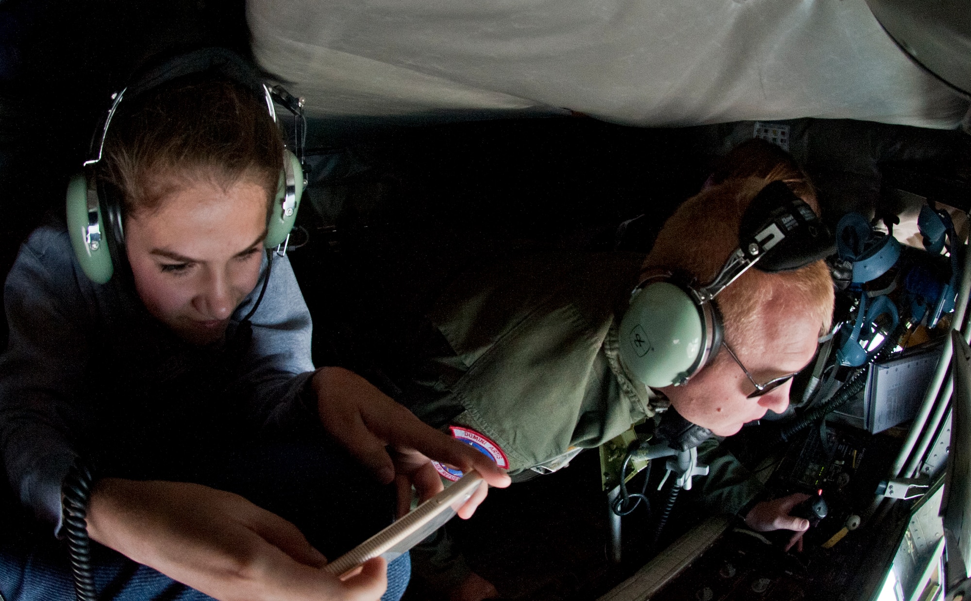 Meghan Long, Lilac Princess queen, takes a photo as Staff Sgt. Jason Markham, 93rd Air Refueling Squadron boom operator, operates the boom pod aboard a KC-135 Stratotanker to refuel an F-15E Strike Eagle June 25, 2015, over the Inland Northwest. The Lilac Princesses Royal Court consists of seven recent high school graduates who are active throughout the community with personal appearances at civic events, elementary schools, hospitals, charitable fund raising activities, military organizations and many activities of festival week. (U.S. Air Force photo/Staff Sgt. Veronica Montes)
