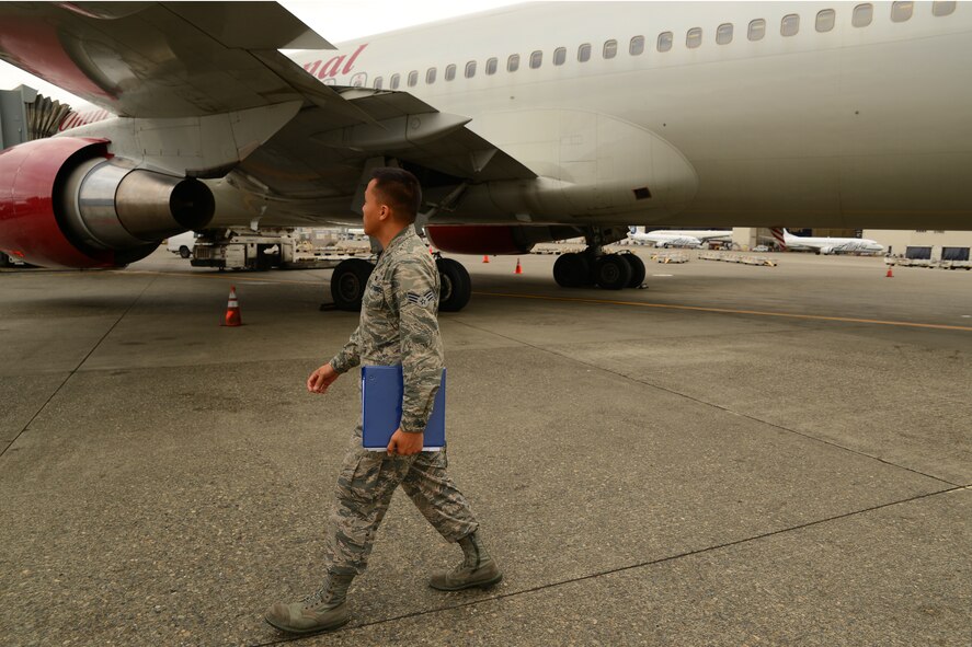 Senior Airman Pao Khang, 62nd Aerial Port Squadron contracting officer representative, conducts an inspection of an overseas flight, June 16, 2015, at SeaTac Airport, Wash. Khang is one of four Airmen from the 62nd APS who work out of SeaTac on a daily basis, but they are assigned Joint Base Lewis-McChord, Wash.  (U.S. Air Force photo by Staff Sgt. Tim Chacon)