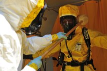 Senior Airman Oshane Wint, left, 4th Aerospace Medicine Squadron bioenvironmental engineer, decontaminates Maj. Michael Smith, 4th AMDS bioenvironmental engineering flight commander, during an integrated base emergency response capabilities training exercise, June 25, 2015, at Seymour Johnson Air Force Base, North Carolina. Individuals undergo decontamination upon return from a hazardous environment to prevent further spread of contamination. (U.S. Air Force photo/Senior Airman John Nieves Camacho)