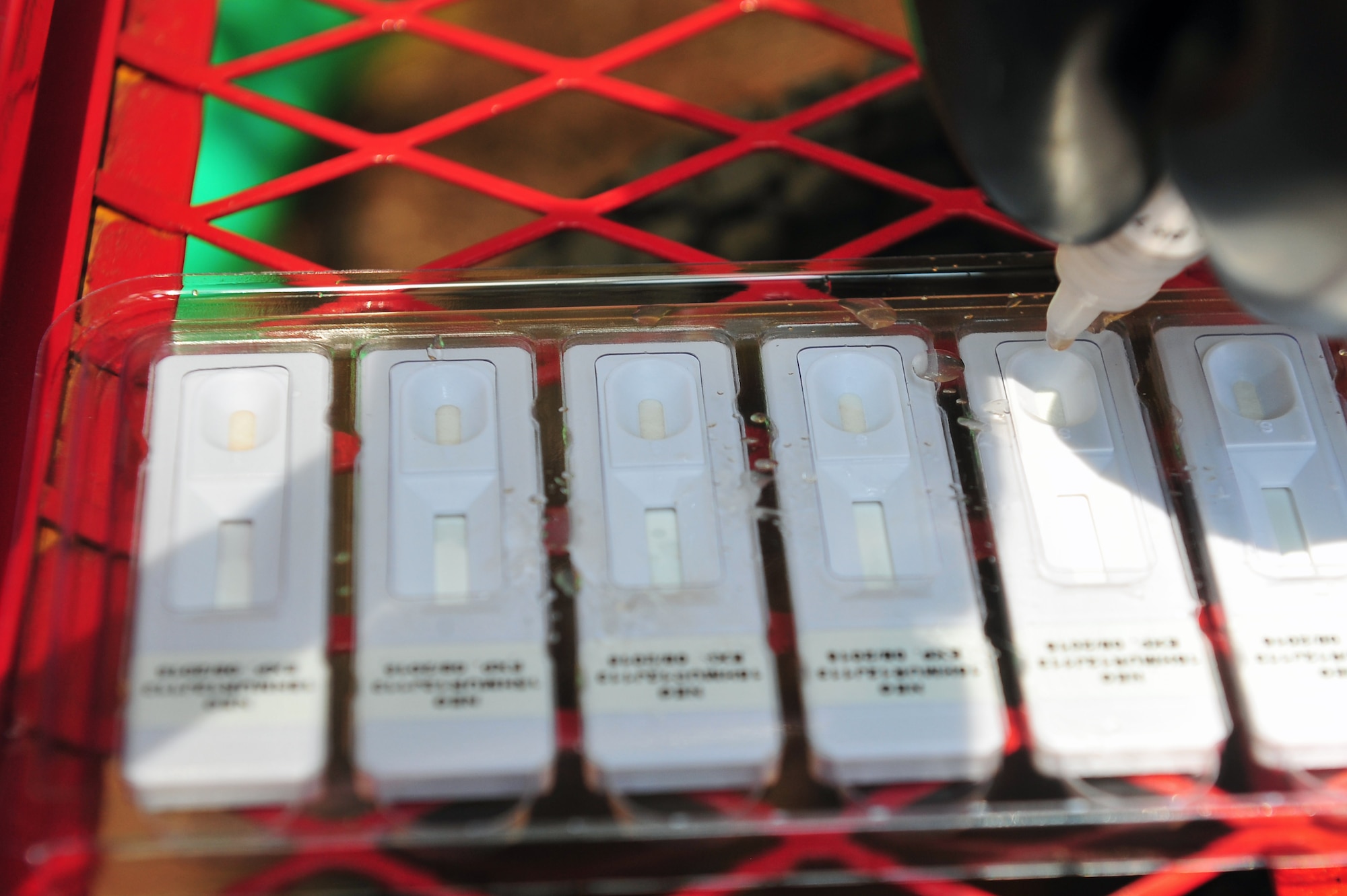 Maj. Michael Smith, 4th Aerospace Medicine Squadron bioenvironmental engineering flight commander, places doses of simulated Staphylococcal Enterotoxin B in a handheld assay during an integrated base emergency response capabilities training exercise, June 25, 2015, at Seymour Johnson Air Force Base, North Carolina. IBERCT consisted of a variety of scenarios that evaluated the responsiveness and knowledge of the participating agencies. (U.S. Air Force photo/Senior Airman John Nieves Camacho)