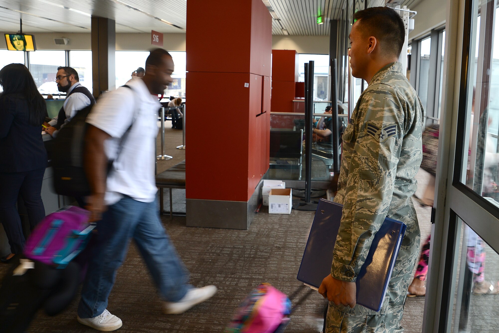 Senior Airman Pao Khang, 62nd Aerial Port Squadron contracting officer representative, oversees passengers loading, June 16, 2015, at SeaTac Airport, Wash. Khang and the other Airmen from the 62nd APS assigned to SeaTac ensure the contractors are adhering to proper load times and making announcements agreed upon in their contract with the Air Force. (U.S. Air Force photo by Staff Sgt. Tim Chacon)