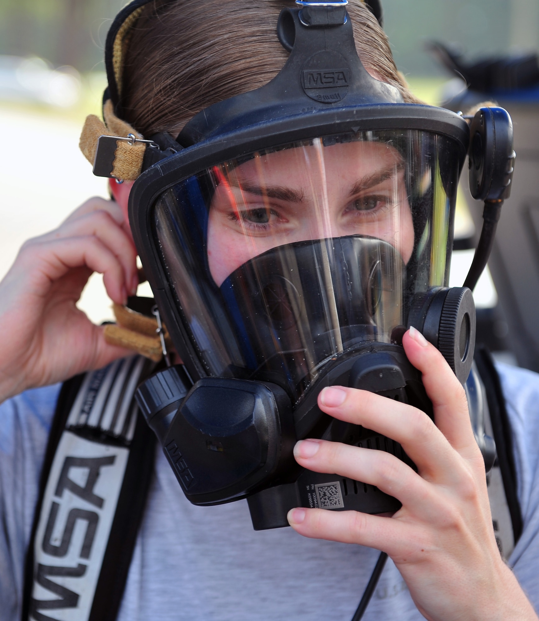 Tech. Sgt. Jessica Clayton, 4th Civil Engineer Squadron emergency management plans section NCO in charge, dons a gas mask during an integrated base emergency response capabilities training exercise, June 24, 2015, at Seymour Johnson Air Force Base, North Carolina. Gas masks are used to protect individuals from harmful airborne pollutants and toxic gases. (U.S. Air Force photo/Senior Airman John Nieves Camacho)