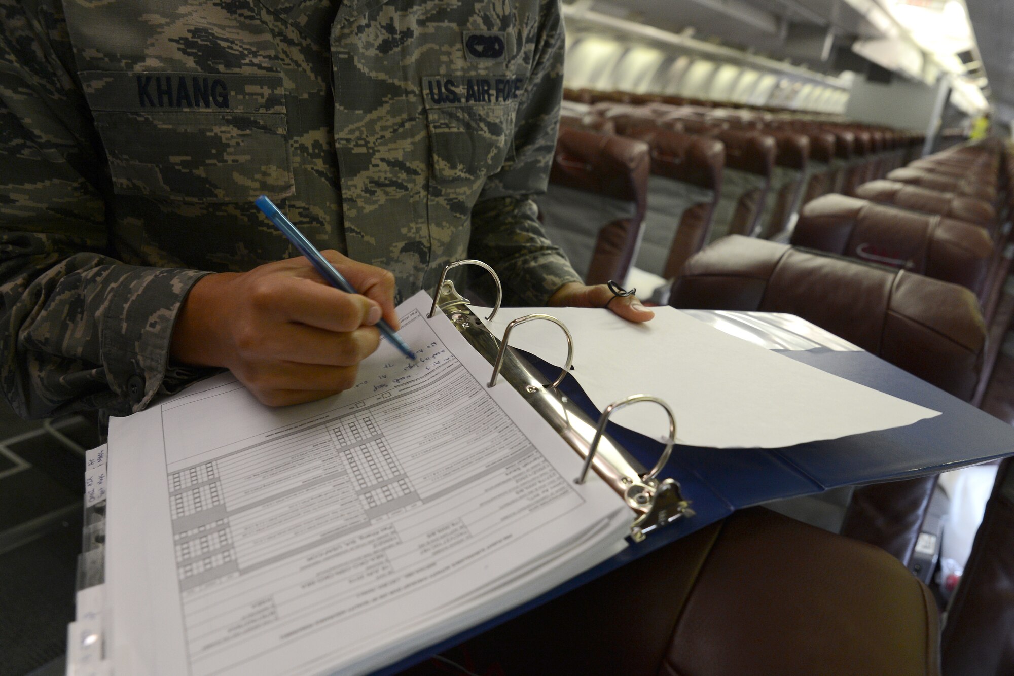Senior Airman Pao Khang, 62nd Aerial Port Squadron contracting officer representative, logs a discrepancy found on an inspection, June 16, 2015, at SeaTac Airport, Wash. Khang inspects the cabin seat by seat to ensure passengers are safe and comfortable on their flight overseas. (U.S. Air Force photo by Staff Sgt. Tim Chacon)