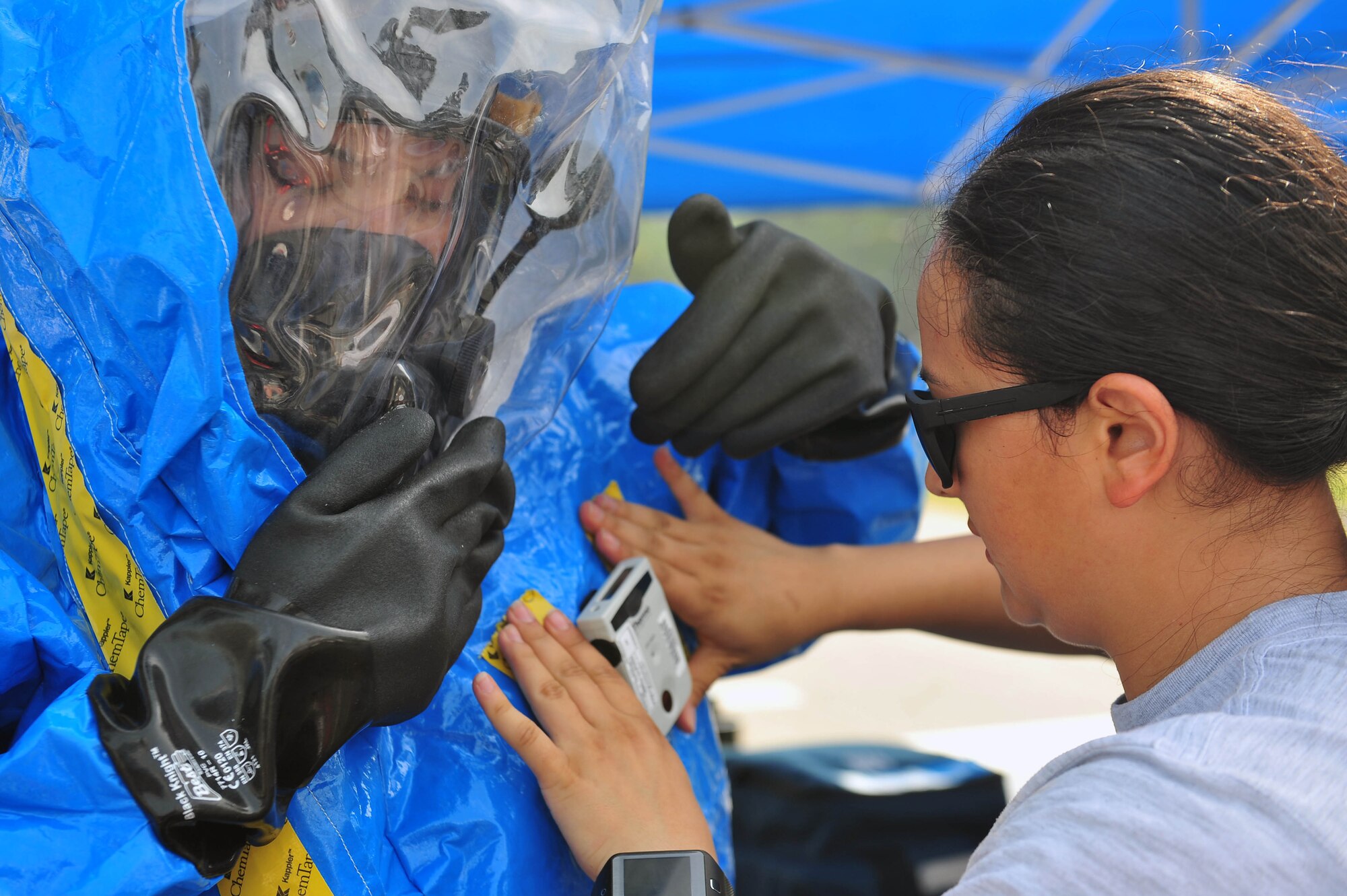 Senior Airman Andrea Spanjer, right, 4th Aerospace Medicine Squadron bioenvironmental engineer, attaches an electronic personal dosimeter to Airman 1st Class Amanda Vazquez-Lloret, 4th AMDS bioenvironmental engineer, during an integrated base emergency response capabilities training exercise, June 24, 2015, at Seymour Johnson Air Force Base, North Carolina. An EPD monitors exposure to radiation levels in real time and emits an audible and visual alarm when radiation presence is high. (U.S. Air Force photo/Senior Airman John Nieves Camacho)