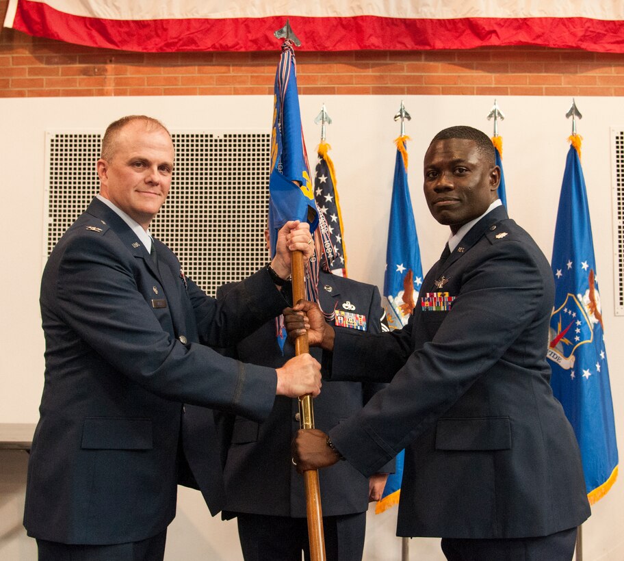 Col. Todd Sauls, 90th Operations Group commander, passes the guidon to Lt. Col. Johnny Galbert, 321st Missile Squadron commander, during the 321st MS change of command June 26, 2015, in the Fall Hall Community Center on F.E. Warren Air Force Base, Wyo. The ceremony signified the transition of command from Lt. Col. Cynthia Gunderson to Galbert. (U.S. Air Force photo by Senior Airman Jason Wiese)
