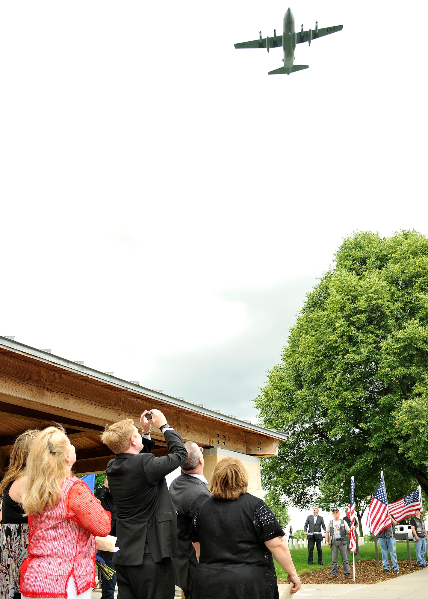 A C-130 aircraft flies over friends and family of Maj. Robert Olson during the Vietnam War veteran's funeral at Fort Snelling National Cemetery, Minn., June 22, 2015. Olson was given a proper burial following the positive identification of his remains through DNA analysis. (U.S. Air Force photo by Senior Airman Xavier Navarro)