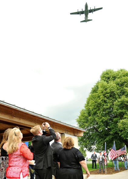 A C-130 aircraft flies over friends and family of Maj. Robert Olson during the Vietnam War veteran's funeral at Fort Snelling National Cemetery, Minn., June 22, 2015. Olson was given a proper burial following the positive identification of his remains through DNA analysis. (U.S. Air Force photo by Senior Airman Xavier Navarro)