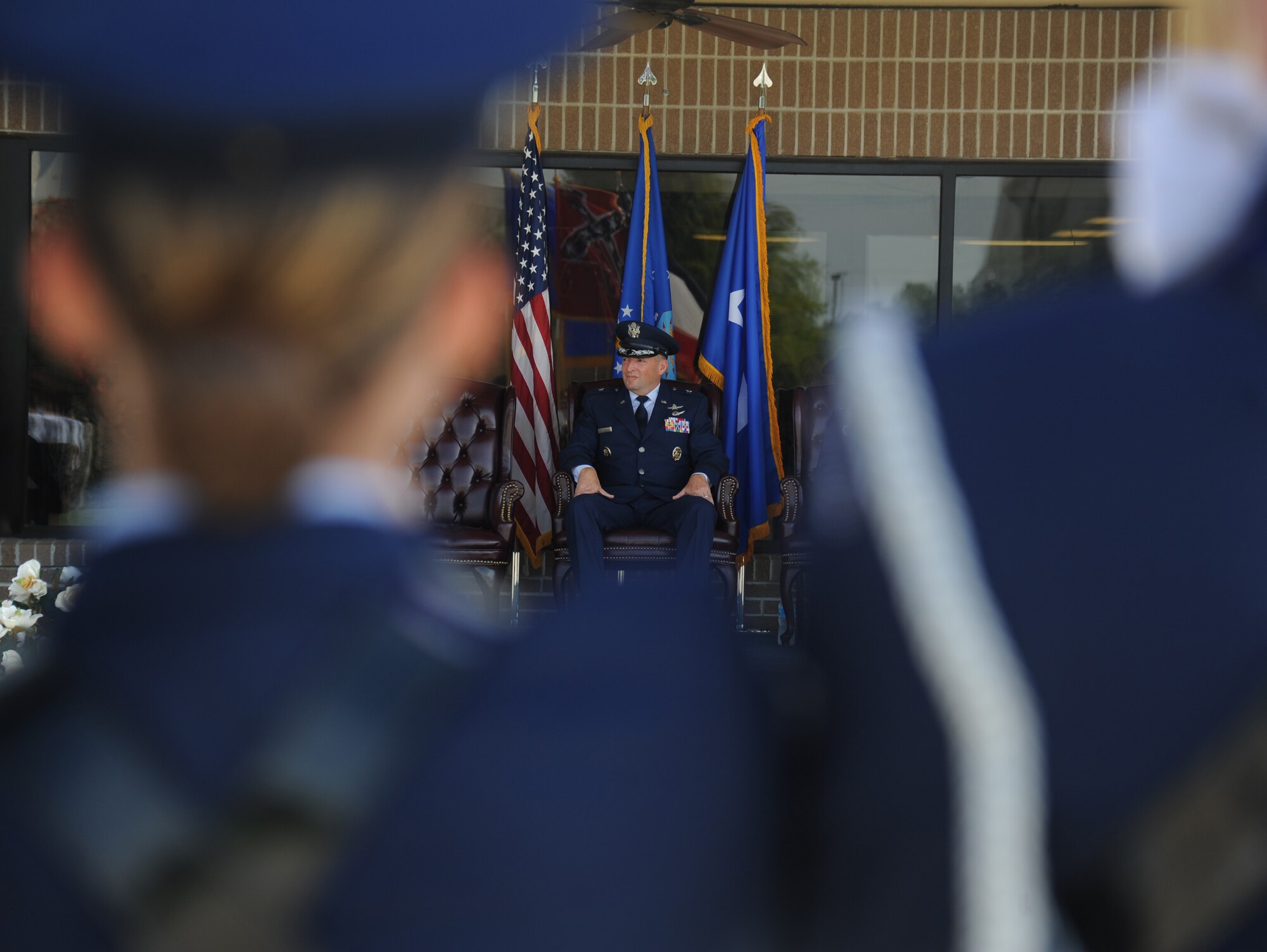 Brig. Gen. Patrick Higby, outgoing 81st Training Wing commander, listens as Col. Michele Edmondson gives her first speech as 81st TRW commander during a change of command, June 26, 2015, Keesler Air Force Base, Miss. Edmondson took command of the 81st TRW from Higby. (U.S. Air Force photo by Senior Airman Holly Mansfield)