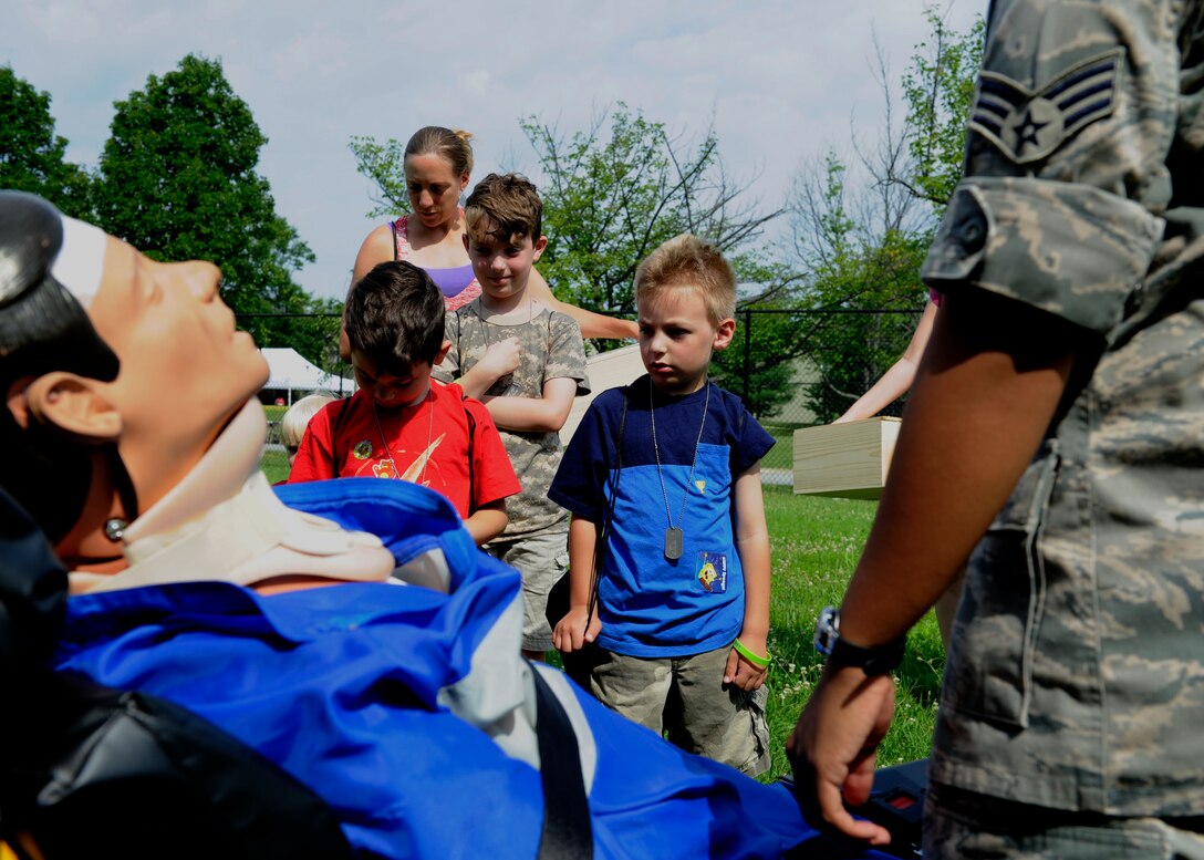 Team Andrews children are shown medical dummies and equipment by Airmen during Operation KID Mode June 25, 2015, at Joint Base Andrews, Md. The event allowed children and families of military members to see the tools they might use while deployed. (U.S. Air Force photo by Senior Airman Preston Webb)