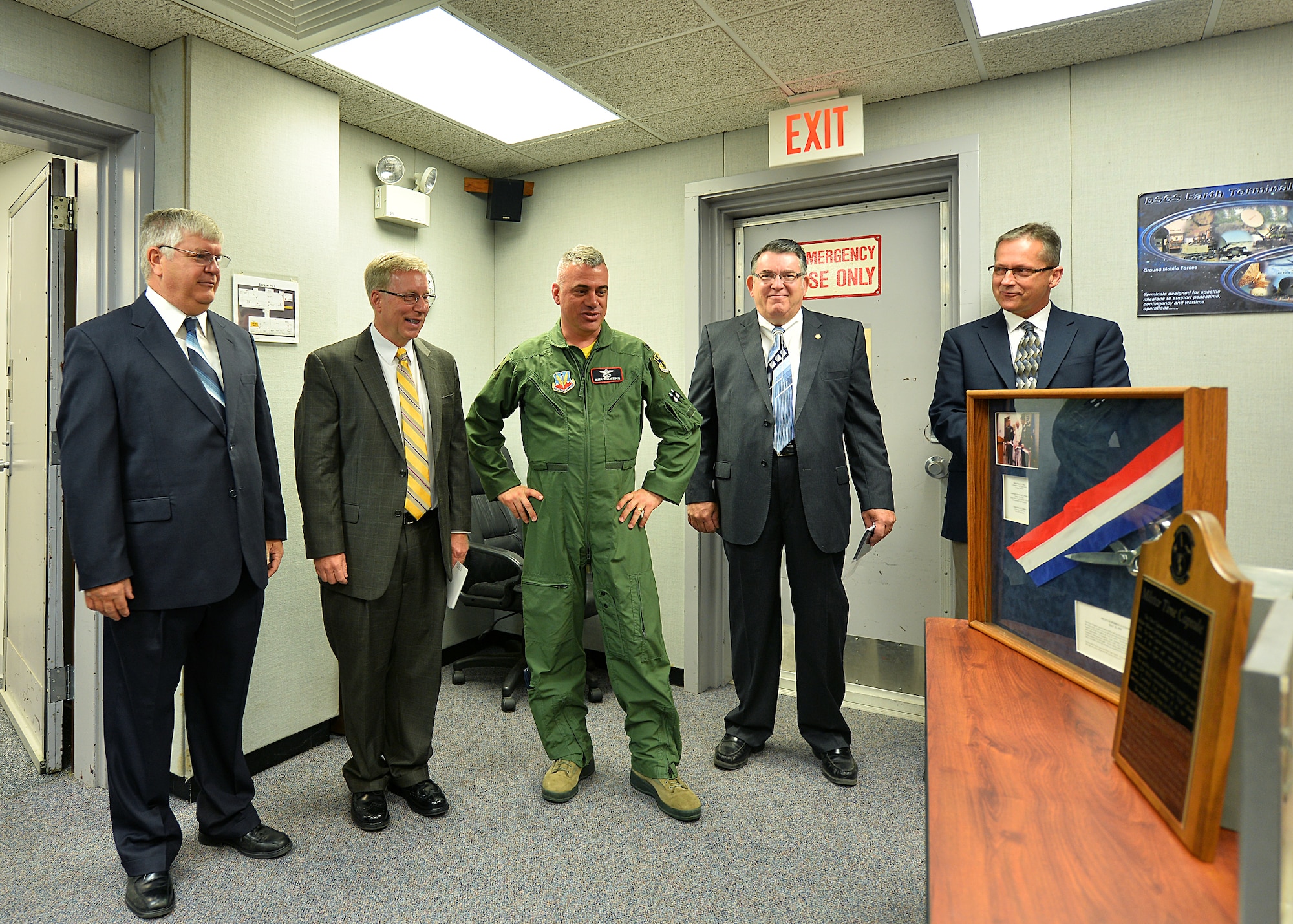 U.S. Air Force Col. Mark Williamson, 55th Wing vice commander, stands among members of the original MILSTAR team as they look at the ribbon cutting shadow box and the time capsule plaque and box June 19 during the unveiling ceremony at Offutt Air Force Base, Neb. In attendance of the event were four original team members: (from left to right) U.S. Air Force Chief Master Sgt. Ret. Bernard Lichvar, U.S. Air Force Lt. Col. Ret. Daniel Clatanoff, U.S. Air Force Master Sgt. Ret. Thomas Reese and Mr. Craig Williams. (U.S. Air Force photo by Charles Haymond/Released)