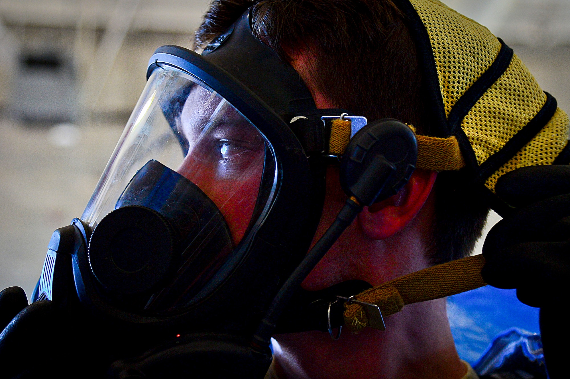 An Airman with the 6th Air Mobility Wing dons a gas mask while suiting up in a Level A hazardous material suit at MacDill Air Force Base, Fla., June 24, 2015. Airmen from emergency management, bioenvironmental engineering and the crash fire station came together for a joint responder training. (U.S. Air Force photo by Senior Airman Ned T. Johnston/Released)