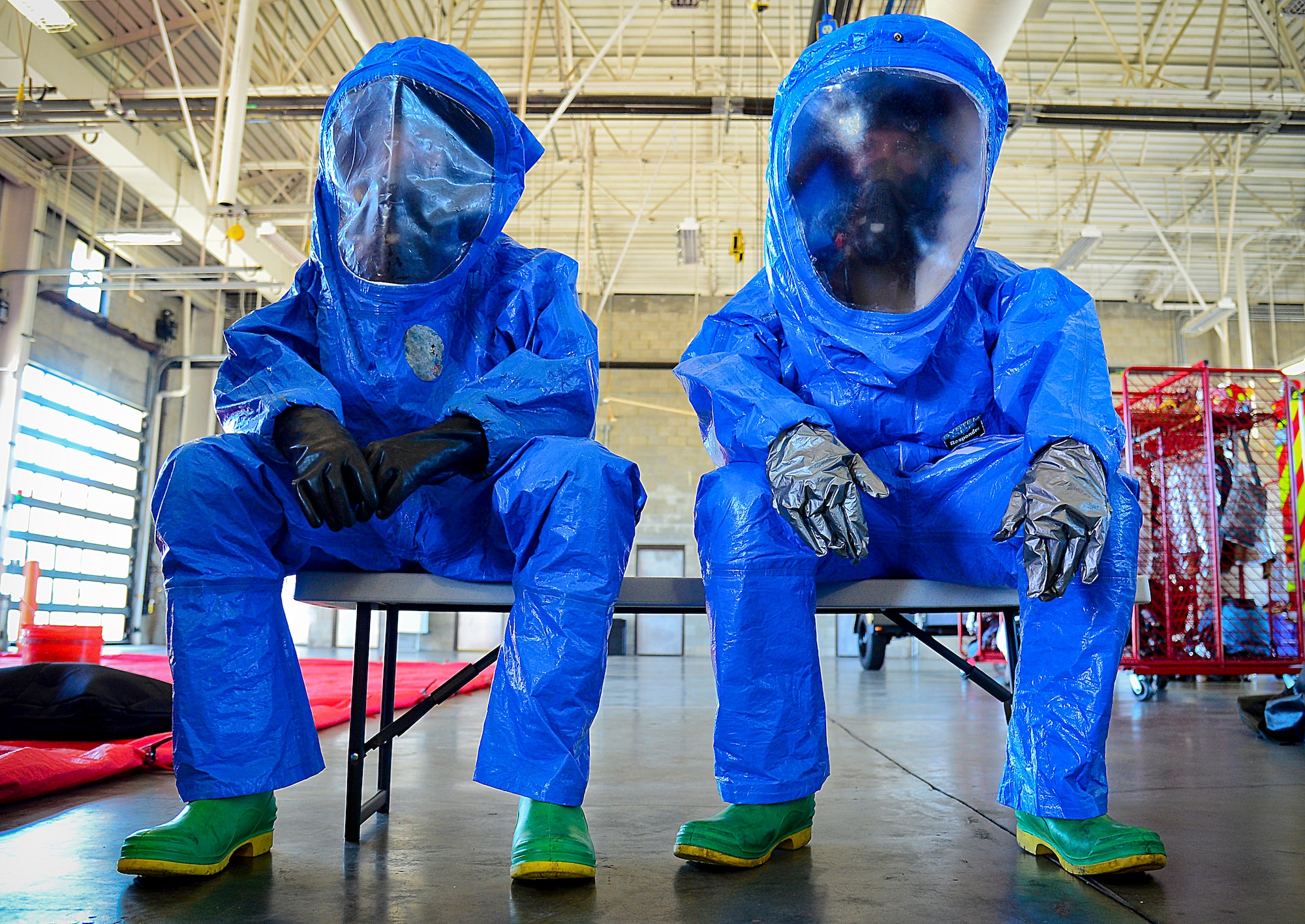 Two 6th Civil Engineering fire fighters prepare to go through a hazardous material decontamination line at MacDill Air Force Base, Fla., June 24, 2015. The joint responder training that involved many on-base agencies started with a classroom refresher followed by the decontamination line. (U.S. Air Force photo by Senior Airman Ned T. Johnston/Released)