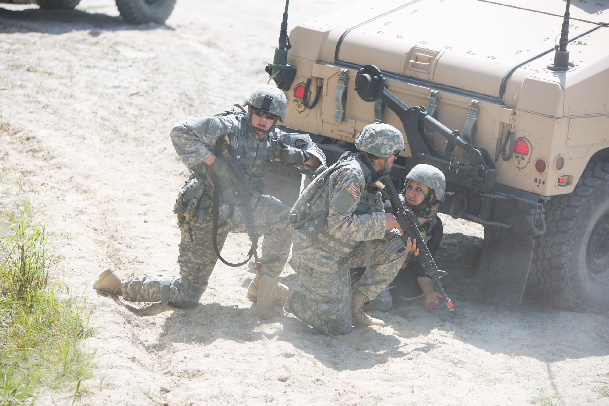 Soldiers from the 50th Infantry Brigade take cover behind a Humvee after a fire fight ensues during Operation Morning Coffee at Warren Grover Gunnery Range, N.J., June 17, 2015. Operation Morning Coffee is a joint exercise with the New Jersey Army National Guard, Air National Guard and Marine Corps Reserve. (U.S. Marine Corps photo by Lance Cpl. Stanley Moy/Released)