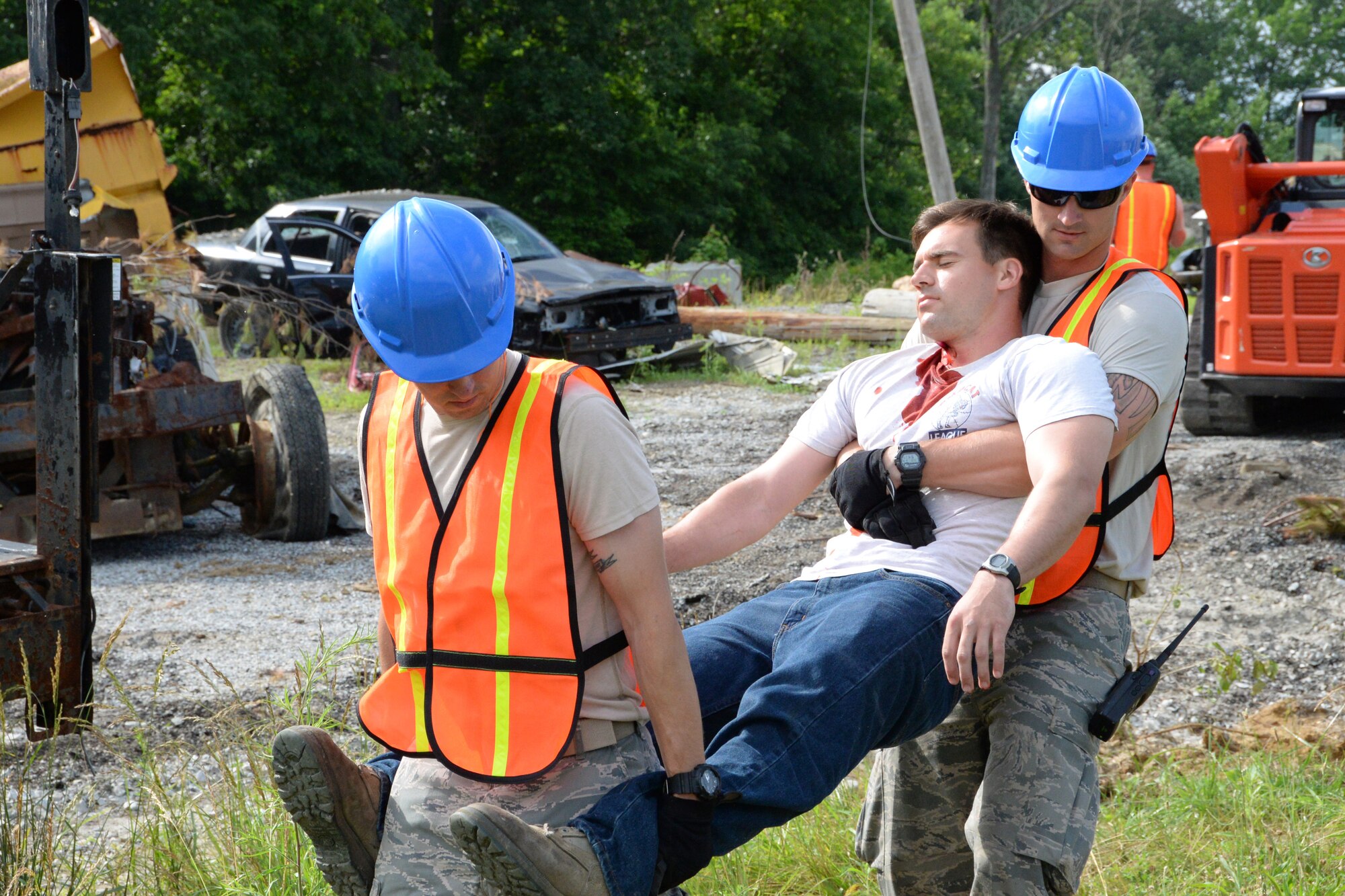 U.S. Air Force Airmen assigned to the 181st Intelligence Wing carry an injured victim away from the wreckage of a simulated hurricane June 16, 2015, at Muscatatuck Urban Training Center near Butlerville Ind. The simulation was part of "Racer Winds," a three-day exercise where the 181st IW worked alongside several civilian units to provide disaster relief. (U. S. Air National Guard photo by Airman 1st Class Kevin D. Schulze/Released)