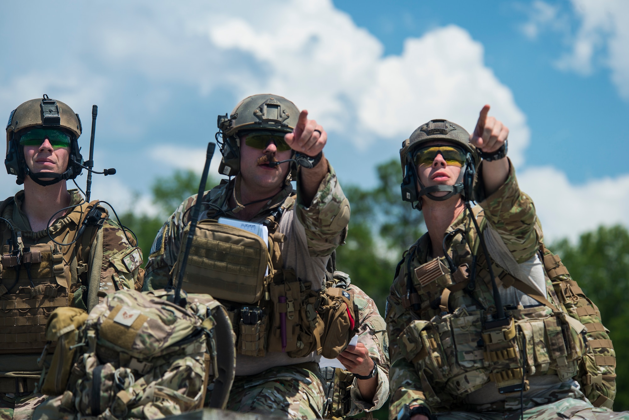 U.S. Air Force Capt. Kyle Spain, 7th Air Support Operations Squadron joint terminal attack controller instructor, left, Staff Sgt. Tyler Puterbaugh, middle, and Tech Sgt. Ron Tyson 7th ASOS tactical air control parties, right, identify a target during a sister squadron scenario June 18, 2015, on Grand Bay Bombing and Gunnery Range at Moody Air Force Base, Ga. The TACPs communicated with A-10C Thunderbolt II pilots to help direct airstrikes. (U.S. Air Force photo by Airman 1st Class Ceaira Tinsley/Released)
