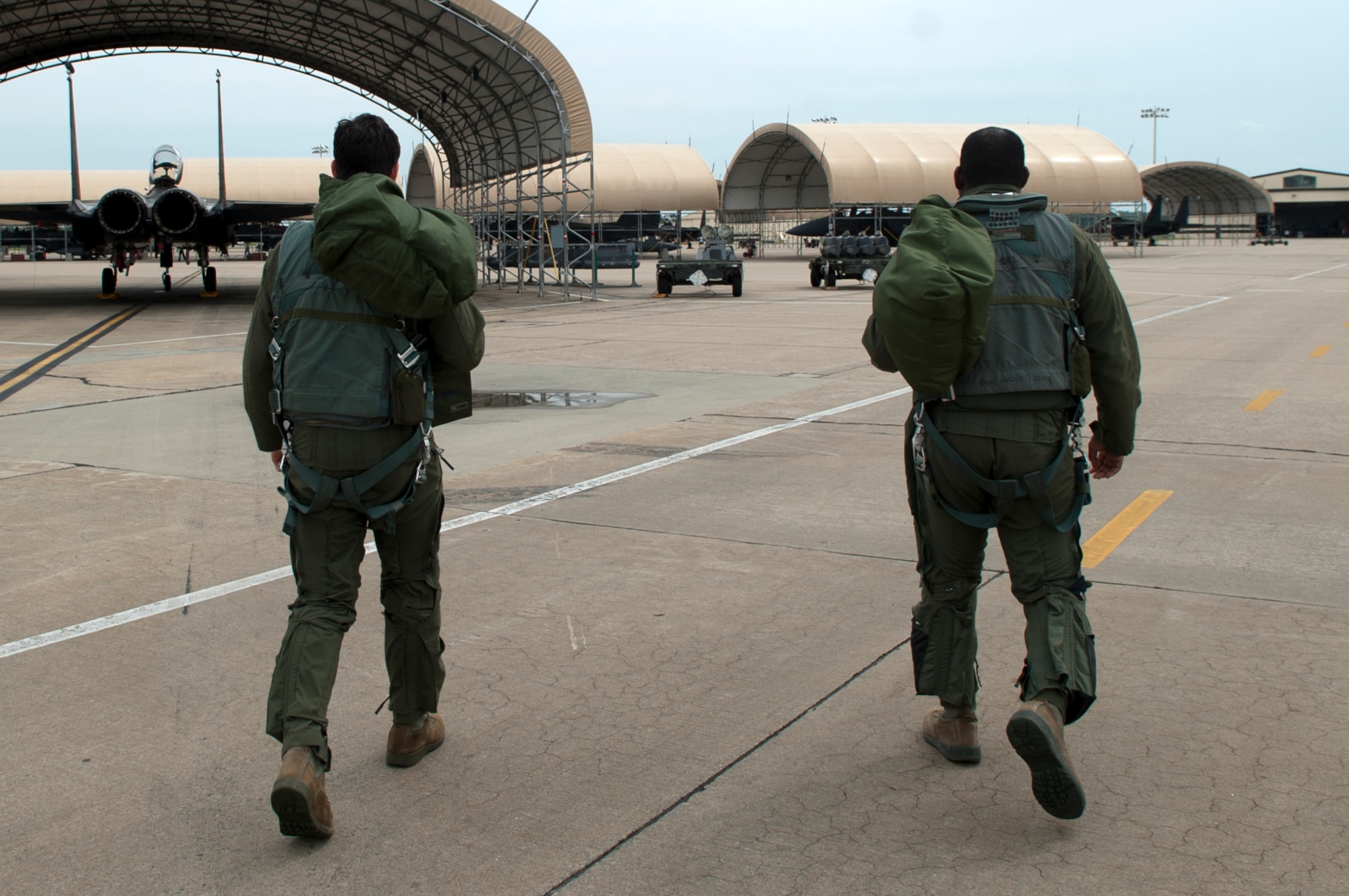 First Lt. Jon Koritz (left), 335th Fighter Squadron pilot, and 1st Lt. Desmond Ross, 336th FS Weapons Systems Officer, walk to an F-15E Strike Eagle, April 20, 2015, at Seymour Johnson Air Force Base, North Carolina. After completing the Basic Course, pilots and WSOs receive additional training in their respective squadrons, called mission qualification check. (U.S. Air Force photo/Airman Shawna L. Keyes)