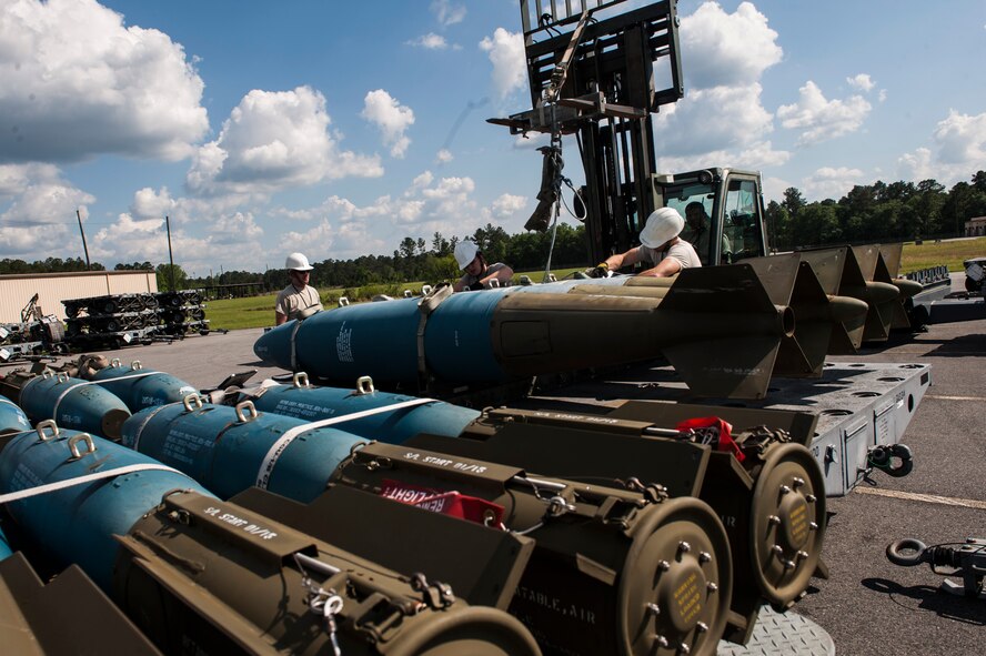 Crew chiefs and members from the 23d Equipment Maintenance Squadron Munitions Flight lift an inert Mk-84 bomb May 6, 2015, at Moody Air Force Base, Ga. The munitions flight prepares all of Moody’s munitions to include bombs, missiles, bullets, grenades and A-10C Thunderbolt II ejection seats. (U.S. Air Force photo by Airman 1st Class Dillian Bamman/Released)
