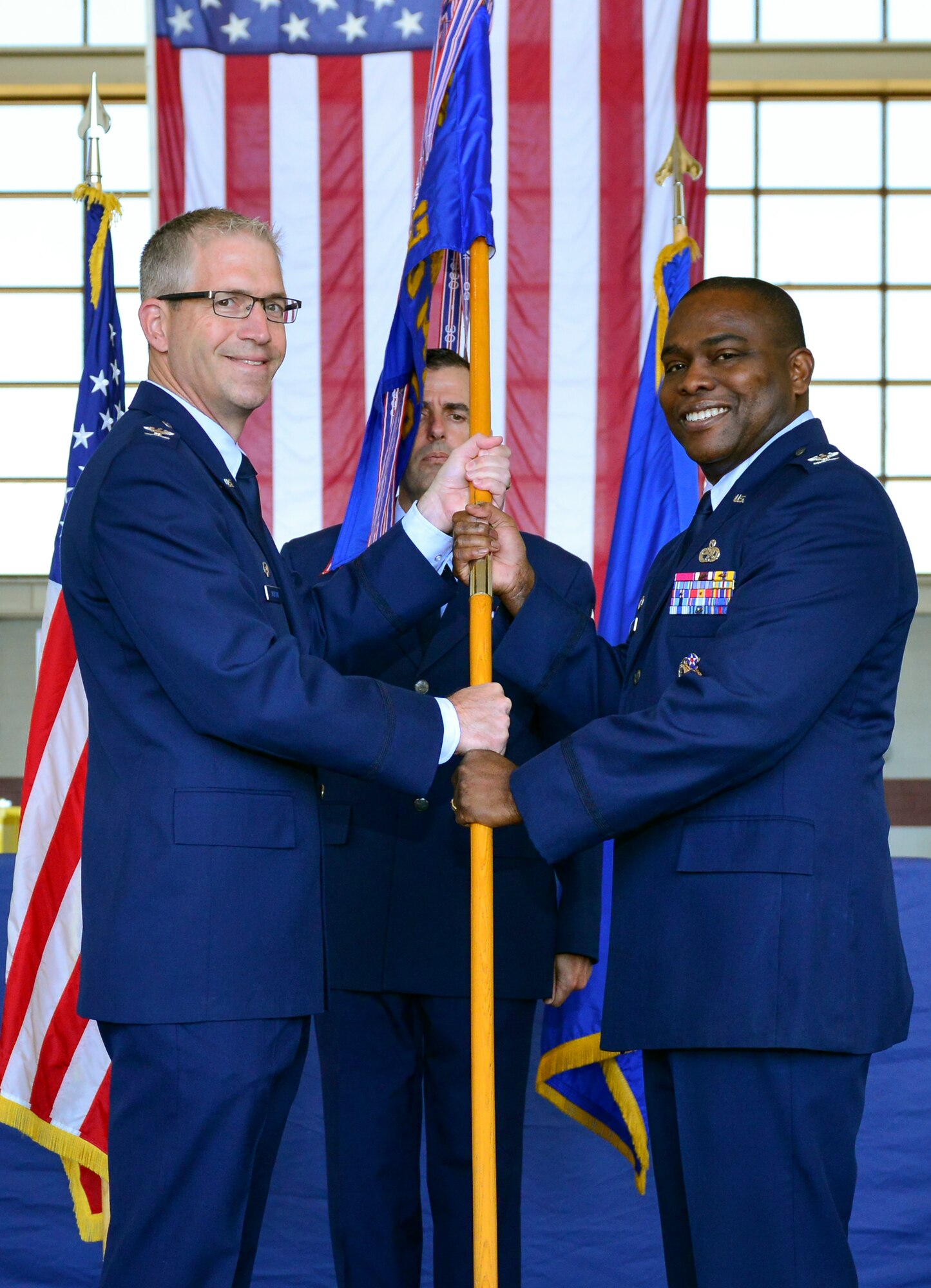 Colonel Joel Jackson, 60th Air Mobility Wing, commander, passes the quidon to Colonel Earl S. Scott who took control of the 60th Maintenance Group during his assumption of command ceremony held at hanger P-14, Travis AFB, June 22, 2015.  Jackson, who officiated the ceremony,  voiced his confidence in the new commander, lauding his previous accomplishments  (U.S. Air Force Photograph by Heide Couch/Released)