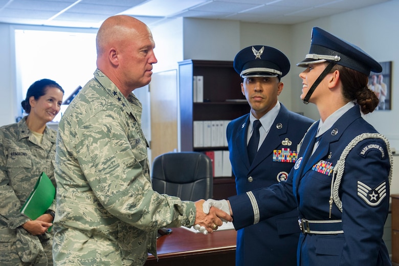 Lt. Gen. John Raymond, U.S. Strategic Command's Joint Functional Component Command for Space and 14th Air Force (Air Forces Strategic) commander, coins, right, Staff Sgt. Jessica Brock, Air Force Space Command Base Honor Guard Member of the Year, while Brig. Gen. Nina Armagno, 45th Space Wing commander, left, and Master Sgt. Jason Charlemagne, AFSPC Base Honor Guard Program Manager of the Year, look on. During Raymond’s one-day visit to Patrick, he visited several units and interacted with Airmen.  (U.S. Air Force photo/Matthew Jurgens) (Released)