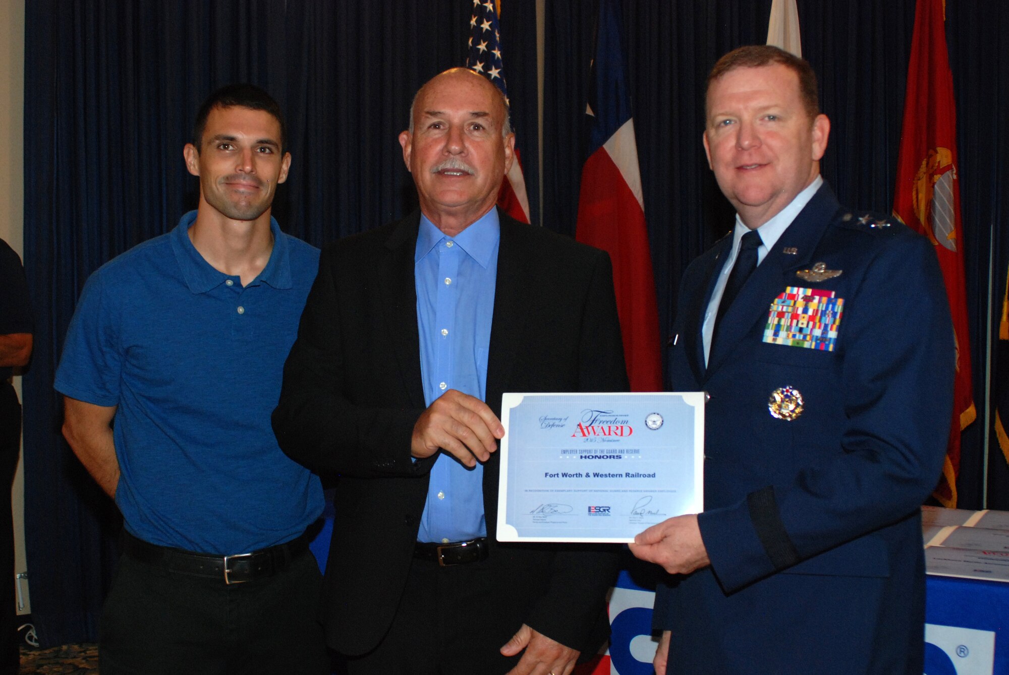 NAVAL AIR STATION FORT WORTH JOINT RESERVE BASE, Texas – Staff Sgt. Luke Hatton, a 301st Aircraft Maintenance Squadron electrician, and Billy Payne, an employer with Fort Worth and Western Railroad as well as Hatton’s civilian supervisor, smile for a photo with Maj. Gen. Richard Scobee, 10th Air Force commander, at a breakfast banquet here June 24 honoring employers. Payne was one of 35 supervisors the Texas Employer Support of the Guard and Reserve (ESGR) recognized for their 2015 Secretary of Defense Employer Support Freedom Award nominations. This award is the highest recognition given by the U.S. Government to employers for their support of their employees who serve in the Guard and Reserve. (U.S. Air Force photo/Senior Airman Ben Calantas)