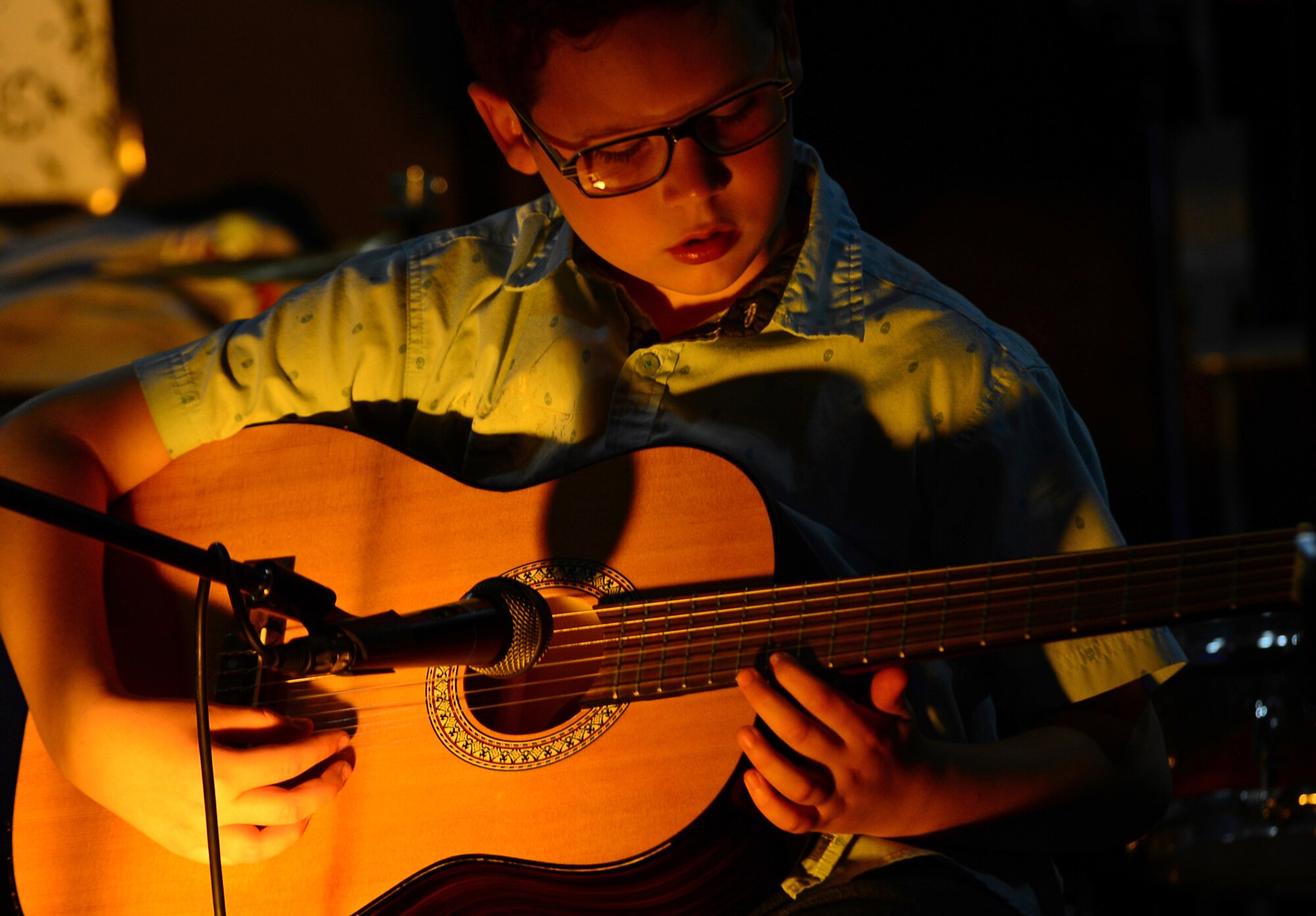 Aadan Wiggington, 10, performs on the guitar at Electric Avenue’s Open Mic Jam Night at Royal Air Force Lakenheath, England, June 17, 2015. The event is held to encourage base personnel of all ages to perform with other local artists, and provides an opportunity for Airmen to showcase their skills through vocal and musical outlets. (U.S. Air Force photo by Senior Airman Erin O’Shea/Released)