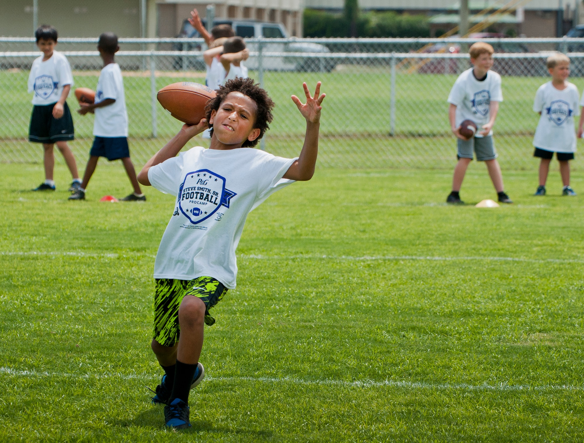 A player learns to throw a spiral pass during the two-day children’s football camp June 24 at Eglin Air Force Base, Fla.  Baltimore Ravens’ wide receiver, Steve Smith, was the professional coach at the camp that taught kids up-tempo football drills, exercises and scrimmages.   Approximately 150 children attended the camp which was made possible because the Eglin Commissary won a Proctor and Gamble sales contest.  (U.S. Air Force photo/Samuel King Jr.)