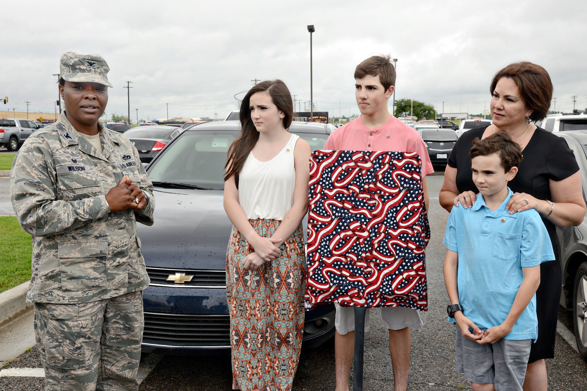 Col. Stephanie Wilson, 72nd Air Base Wing and Tinker installation commander, gives remarks before the June 18 unveiling of two parking spaces reserved for Gold Star families at the Tinker Exchange. With the colonel is the family of Capt. Nathan Nylander, who led the effort to have the signs installed at the BX. Captain Nylander, an Air Force meteorologist, was killed in the line of duty in Afghanistan in 2011. (Air Force photo by Kelly White/Released)