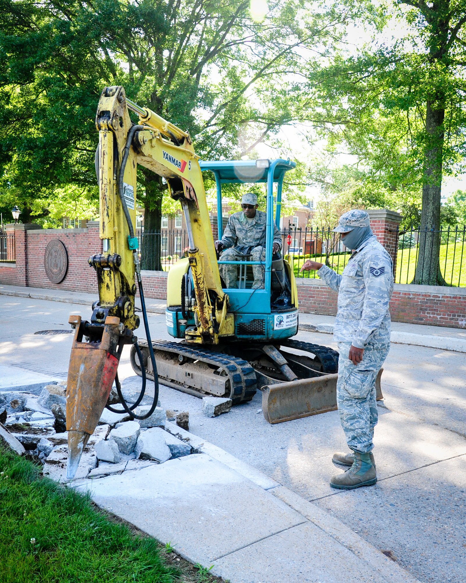 113th Civil Engineer Squadron Heavy Equipment Operators Staff Sgt. Keenan Willis and Airman 1st Class Timothy Blake replace an old section of sidewalk during a deployment for training to the U.S Coast Guard Academy.  (U.S. Air National Guard photo by Chief Master Sgt. Andrew Baker)