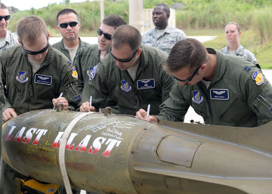 Airmen from the 20th Expeditionary Bomb Squadron sign the ‘Last Blast’ June 24, 2015, at Andersen Air Force Base, Guam. With the help of 36th Munitions Squadron Airmen, 20th EBS aircrew dropped the final M117 bomb in the Pacific Air Force’s inventory June 26 on an uninhabited island off the coast of Guam. (U.S. Air Force photo by Airman 1st Class Joshua Smoot/Released)