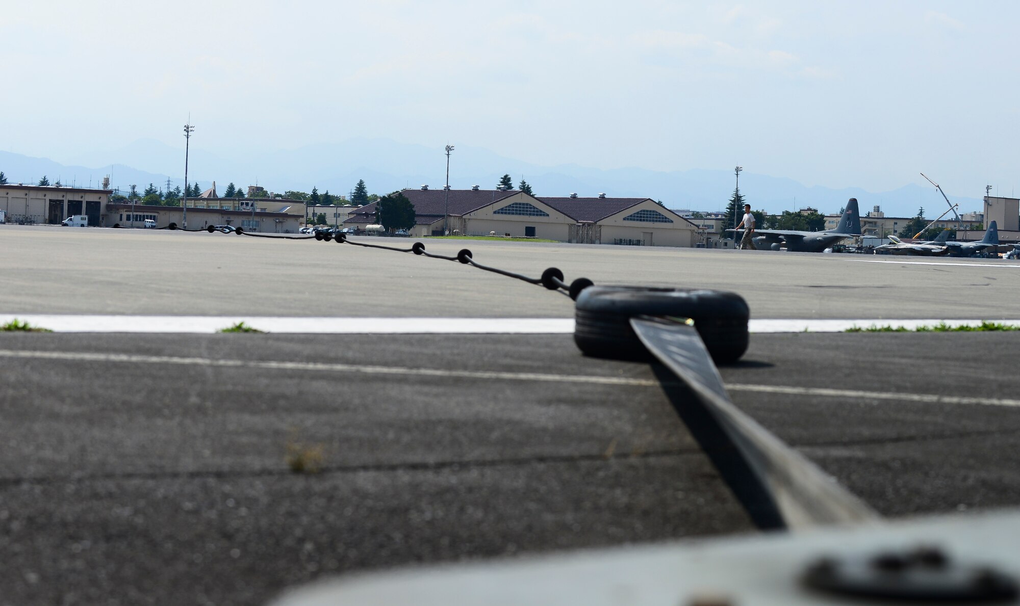 The aircraft arresting system sits after being used at Yokota Air Base, Japan, June 24, 2015. The aircraft arresting system consists of a steel cable attached to 1,200 feet of high-strength nylon tape wrapped in a metal reel. (U.S. Air Force photo by Senior Airman David Owsianka/Released)