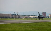 An F-16 Fighting Falcon from Misawa Air Base, Japan, slows down on the runway at Yokota Air Base, Japan, June 24, 2015. As the reel of the aircraft arresting system spins it activates a hydraulic pump which compresses a brake pad to safely slow the aircraft. The aircraft can go from a speed of 180 knots to a complete hault in approximately 10 seconds. (U.S. Air Force photo by Senior Airman David Owsianka/Released)