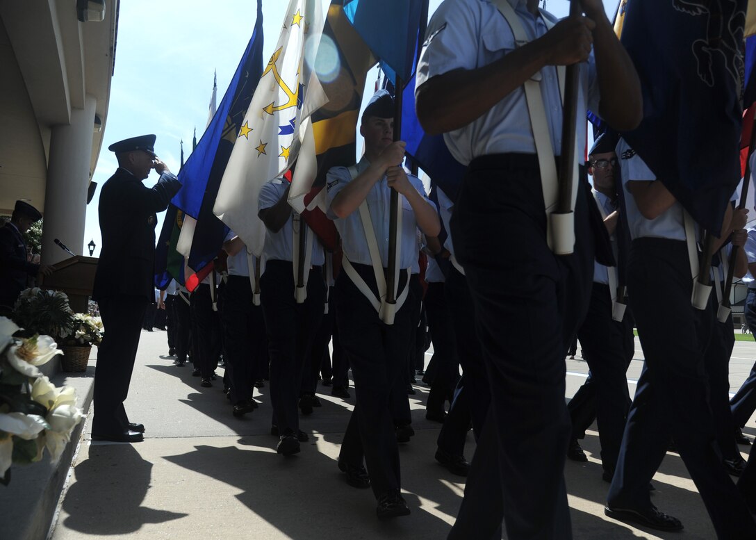 Brig. Gen. Patrick Higby, outgoing 81st Training Wing commander, salutes as members of the 336th Training Squadron carry the 50 state flags during pass and review at a change of command ceremony, June 26, 2015 at Keesler Air Force Base, Mississippi. Col. Michele Edmondson, 81st TRW commander, took command of the 81st TRW from Higby. (U.S. Air Force photo by Senior Airman Holly Mansfield) 