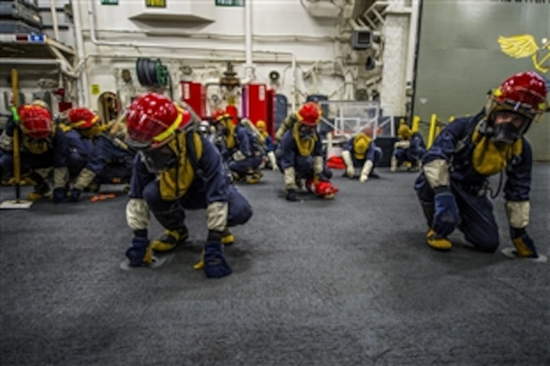 U.S. sailors brace for shock in the hangar bay of the amphibious assault ship USS Essex during a general quarters drill in the Indian Ocean, June 24, 2015. The Essex is supporting maritime security operations and theater security cooperation efforts in the U.S. 5th Fleet area of operations. 
