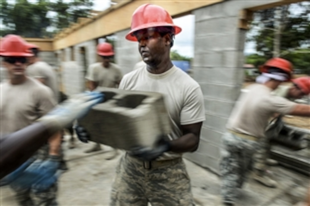 U.S. airmen and Marines move bricks to the interior of a schoolhouse during New Horizons Honduras 2015 training near Trujillo, Honduras, June 24, 2015. The airmen are assigned to the 823rd Expeditionary Red Horse Squadron, and the Marines are assigned to the 271st Marine Wing Support Squadron, 2nd Marine Air Wing,
