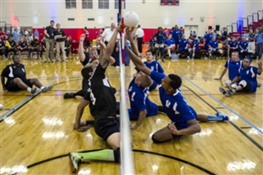 Former Army Spc. Dustin Barr, left, goes for a block at the net during a sitting volleyball match against Team Air Force in the 2015 Department of Defense Warrior Games at Marine Corps Base Quantico, Va., June 25, 2015.