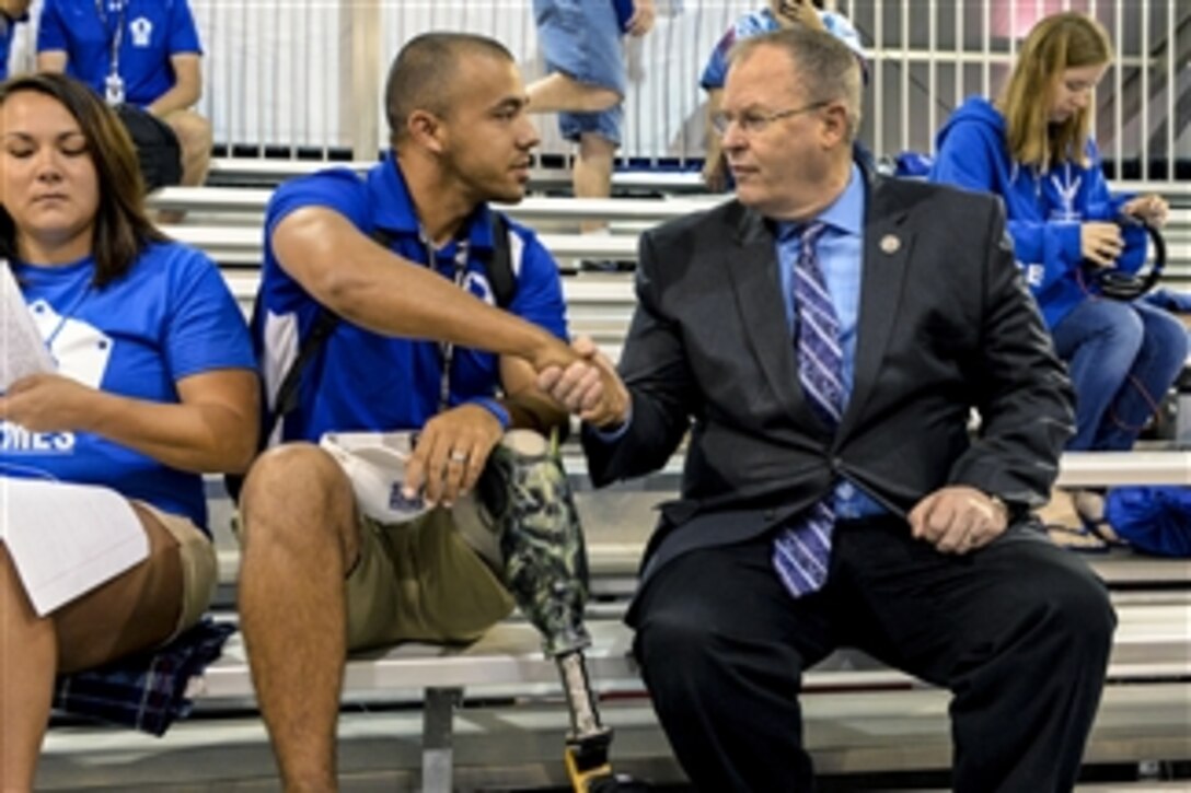 Deputy Defense Secretary Bob Work talks with a military athlete at the 2015 Department of Defense Warrior Games shooting competition on Marine Corps Base Quantico, Va., June 26, 2015.