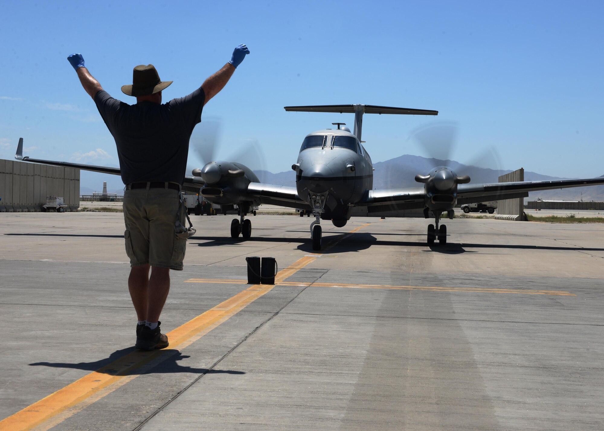 Shawn Hall, 455th Expeditionary Aircraft Maintenance Squadron aircraft mechanic, marshals in a MC-12W aircraft June 26, 2015, at Bagram Airfield, Afghanistan. Hall is part of the Project liberty team that is deployed here in support of NATO’s Resolute Support mission. (U.S. Air Force photo  by Senior Airman Cierra 
