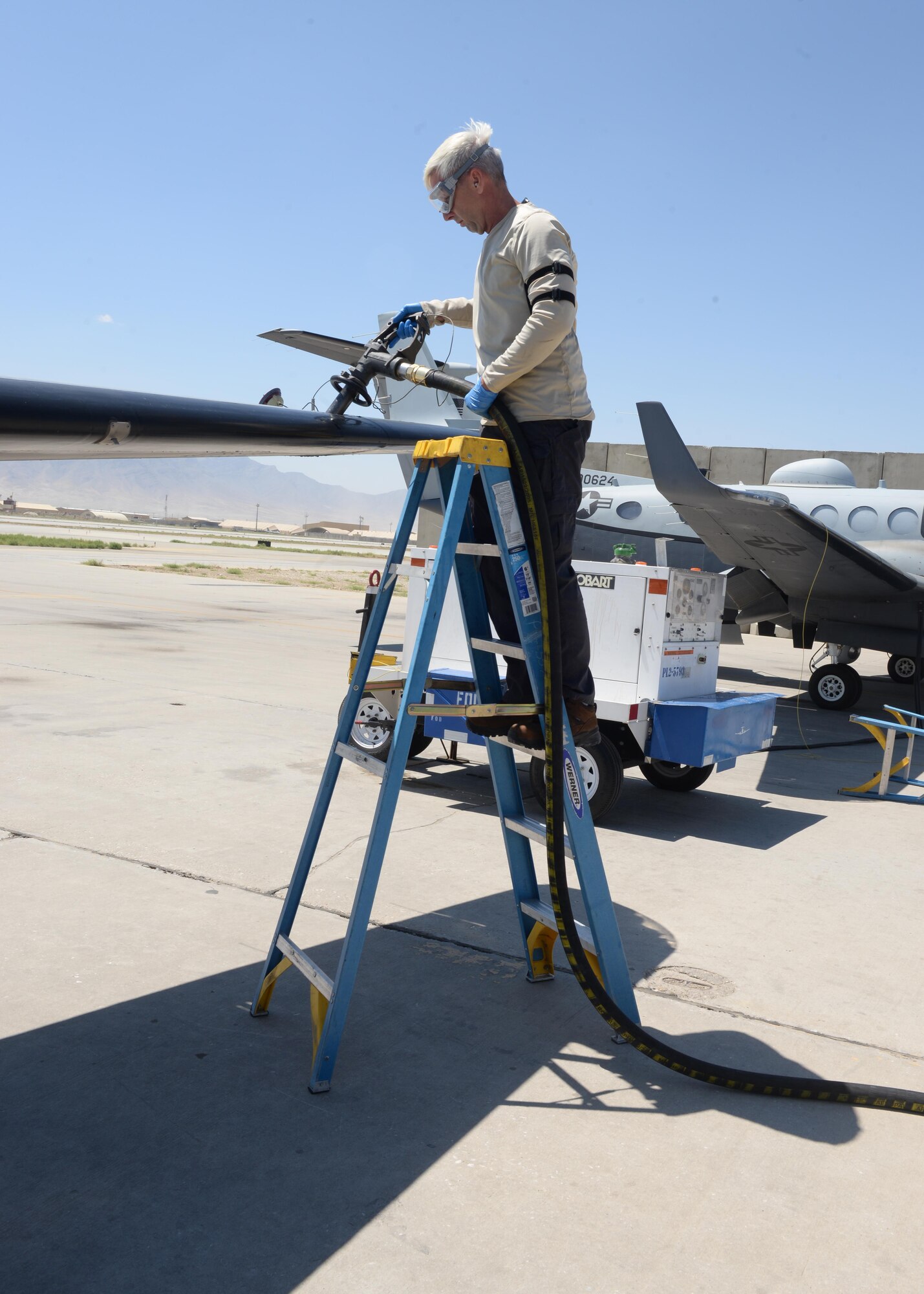 Jeffery Hinchey, 455th Expeditionary Aircraft Maintenance Squadron aircraft mechanic, fuels an MC-12W aircraft prior to its takeoff June 26, 2015, at Bagram, Airfield, Afghanistan. Hinchey is part of the Project Liberty team that is deployed here in support of NATO’s Resolute Support mission. (U.S. Air Force photo by Senior Airman Cierra Presentado/Released)