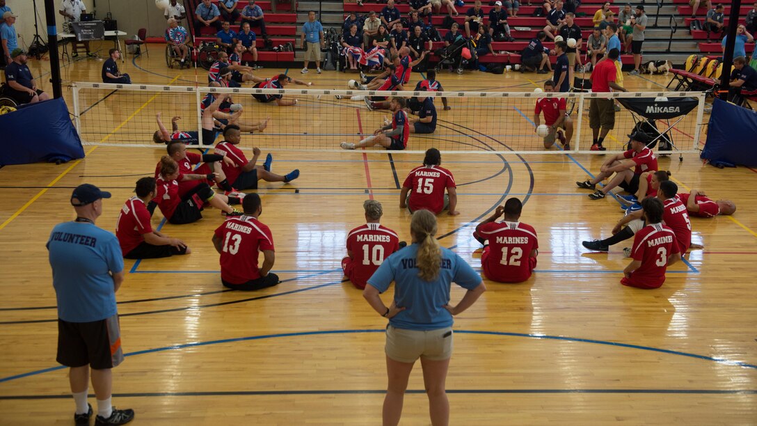Members of team Marines and team British Forces warm up during the 2015 Department of Defense Warrior Games sitting volleyball at Marine Corps Base Quantico, Virginia, June 19-28, 2015. The Warrior Games, founded in 2010, is a Paralympic-style competition that features eight adaptive sports for wounded, ill, and injured service members and veterans from the U.S. Army, Marine Corp, Navy/Coast Guard, Air Force, Special Operations Command, and the British Armed Forces. This year marks the first time the DoD takes responsibility for operational planning and coordination of the event, in which approximately 250 athletes are expected to compete.